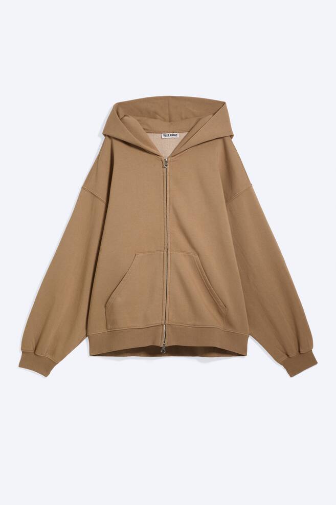 A brown zip hoodie is shown from the front, featuring an oversized, slouchy silhouette. It is displaying a spacious double-layered hood without drawstrings, dropped shoulders, a concealed two-way zip, large pockets, and ribbed cuffs and hem. - 1