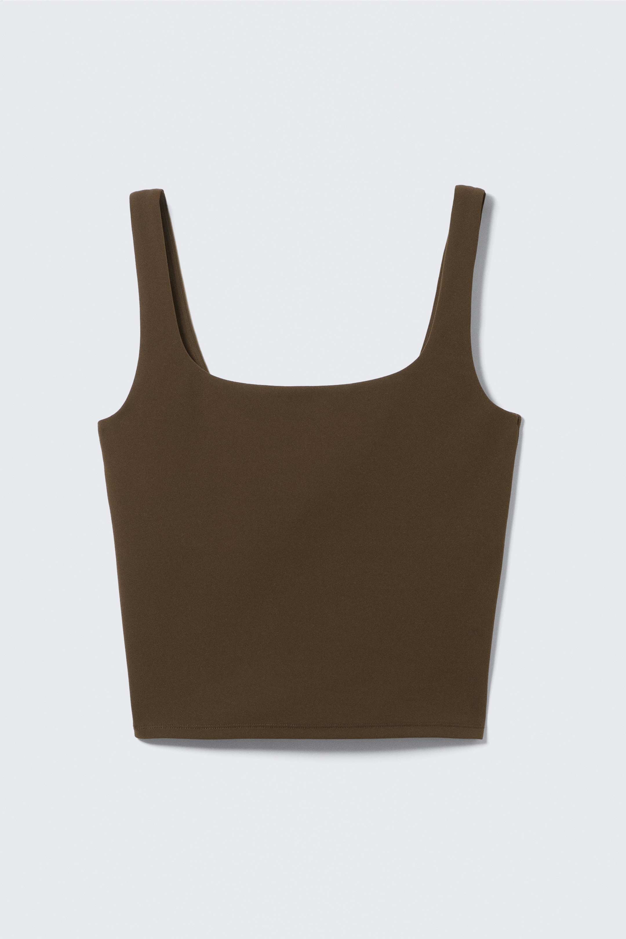 Grotere afbeelding bekijken: Een donkerbruin cropped tanktop wordt van voren getoond, met een vierkante halslijn, brede schouderbanden en een rechte zoom.