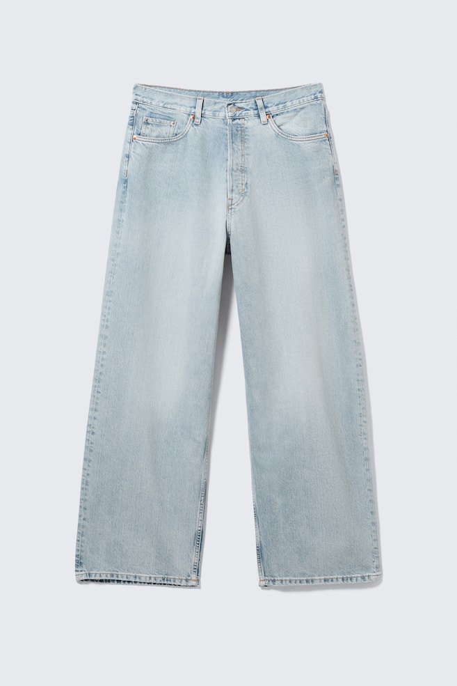 Un paio di jeans in denim azzurro chiaro viene presentato come FRONTALE, mettendo in risalto una vita media, una vestibilità ampia e una gamba larga. Presenta un classico design a cinque tasche con una tasca portamonete visibile e una chiusura a bottoni. - 1