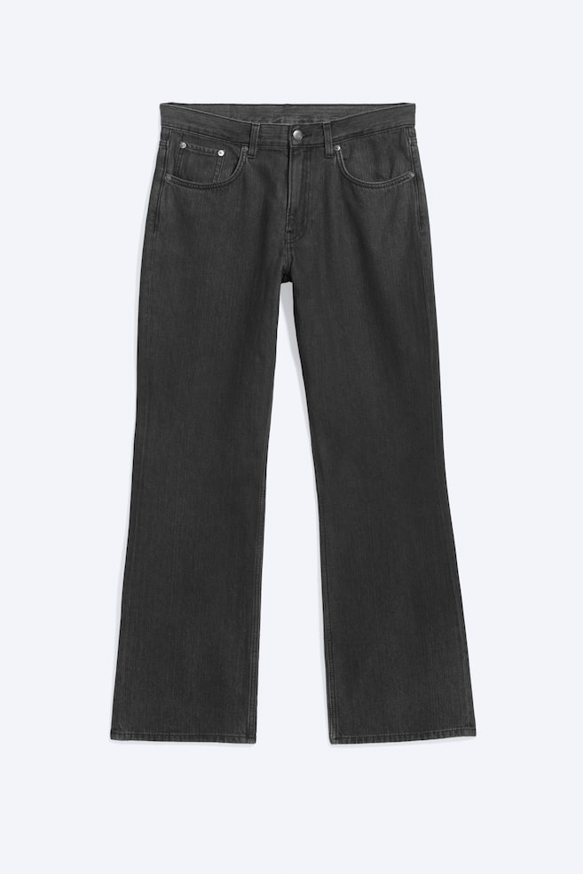 Ce jean gris foncé, présenté de face, arbore une coupe classique à cinq poches, des passants de ceinture et une fermeture centrale par bouton avec braguette zippée. Le jean affiche une silhouette droite avec un léger évasement à lâourlet et un délavage subtilement délavé. - 1