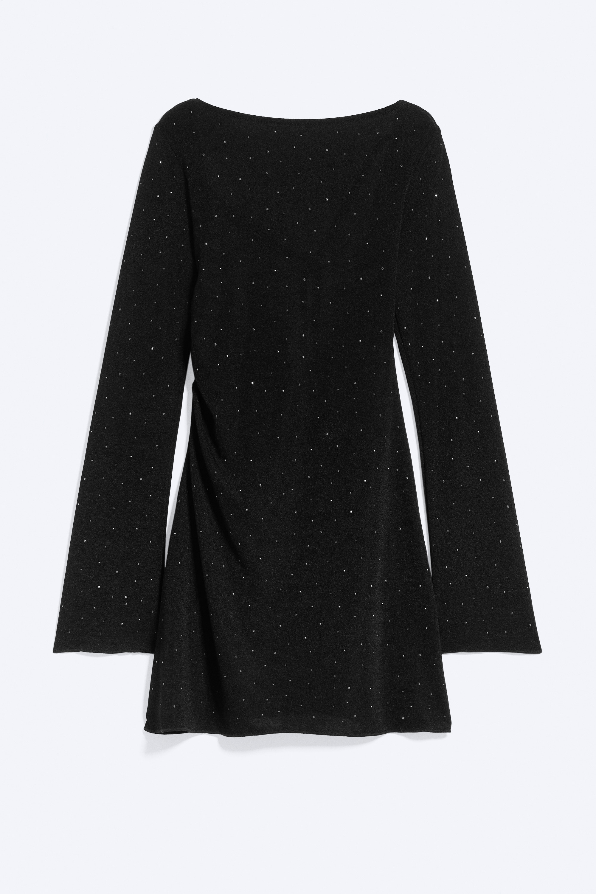 A black slim-fit mini dress featuring long sleeves and all-over rhinestone detailing is being worn by the model. The dress is styled with black pointed-toe heeled ankle boots.
