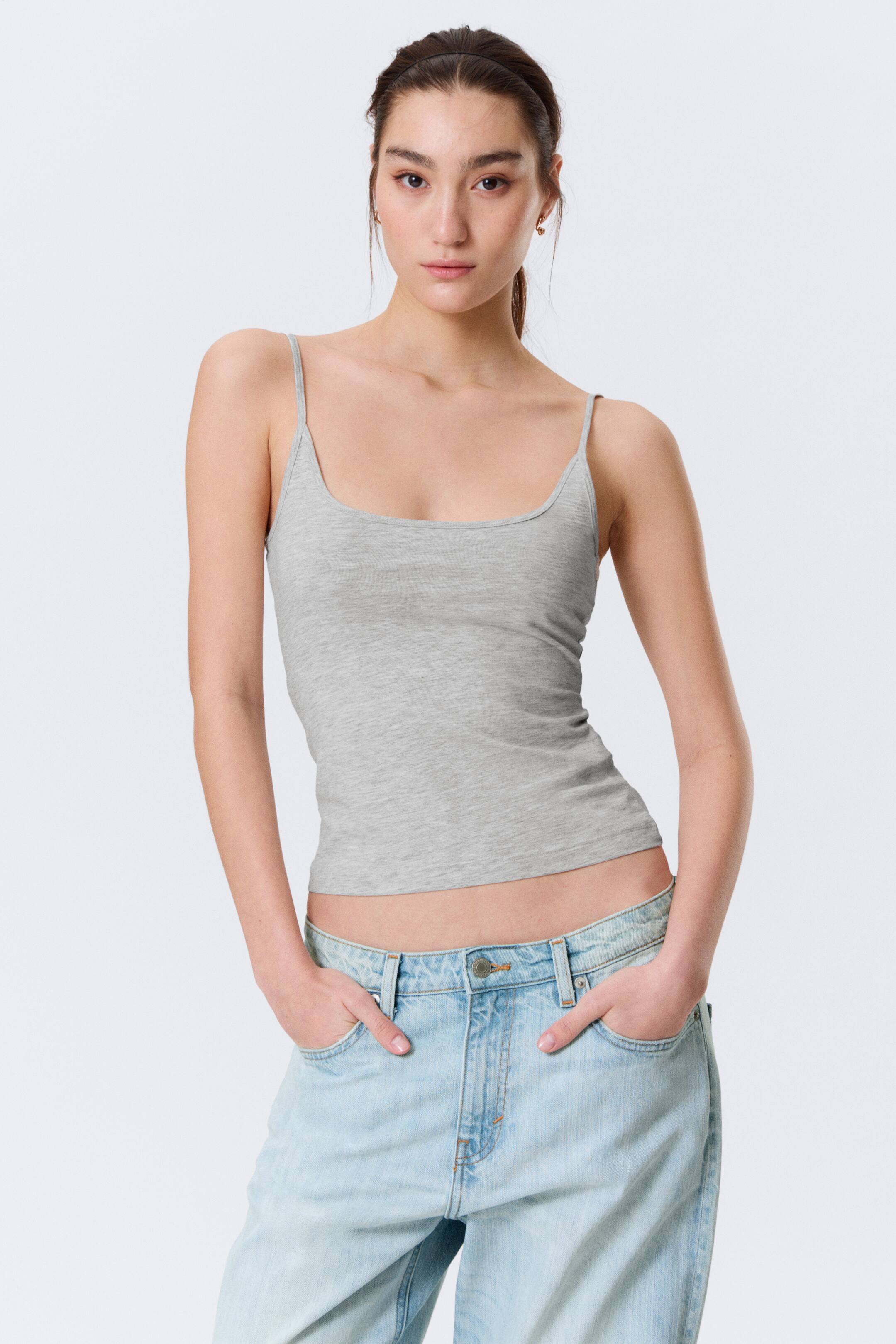 Agrandir l'image: Le débardeur gris présente un décolleté carré, de fines bretelles spaghetti et une texture en maille fine, offrant une silhouette ajustée et raccourcie lorsqu'il est porté de face.