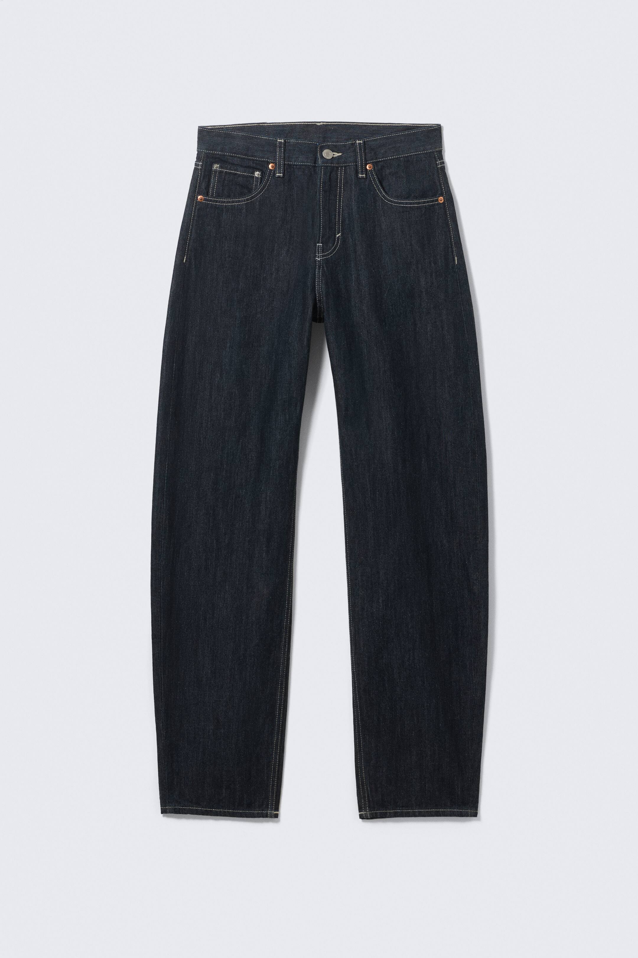 Vis større bilde: Mørkvaskede denimjeans viser et rett benkutt fra FORAN, med kontrastfarget lys søm, femlommers stil og en knappelukking i midjen.