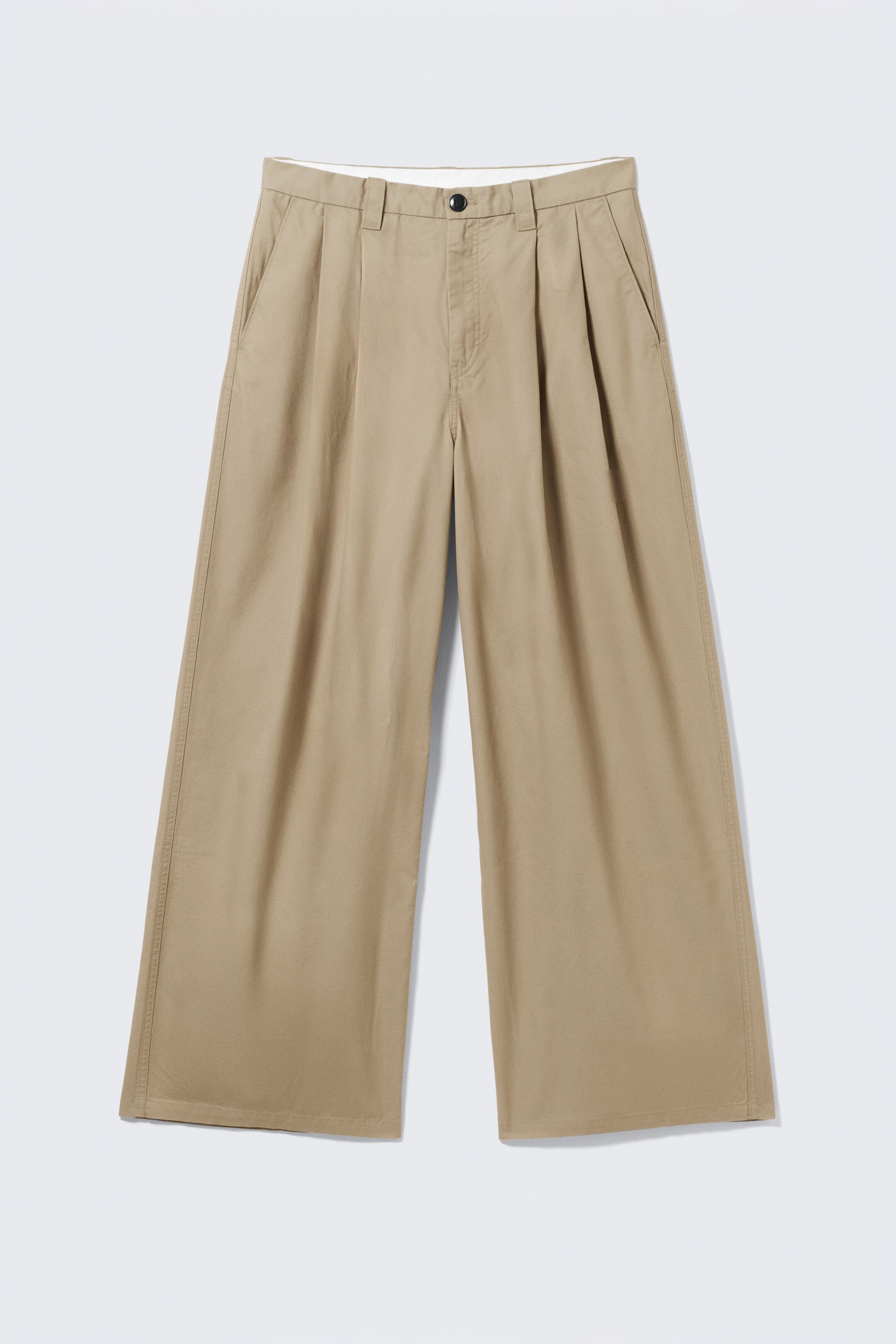 Se større billede: Et par tan bomuldstwill oversized chinos præsenteres fra FRONTEN, med en poset silhuet og bredt ben. De inkluderer to forreste læg på hver side, skrå sidelommer, bæltestropper og en topknaplukning.