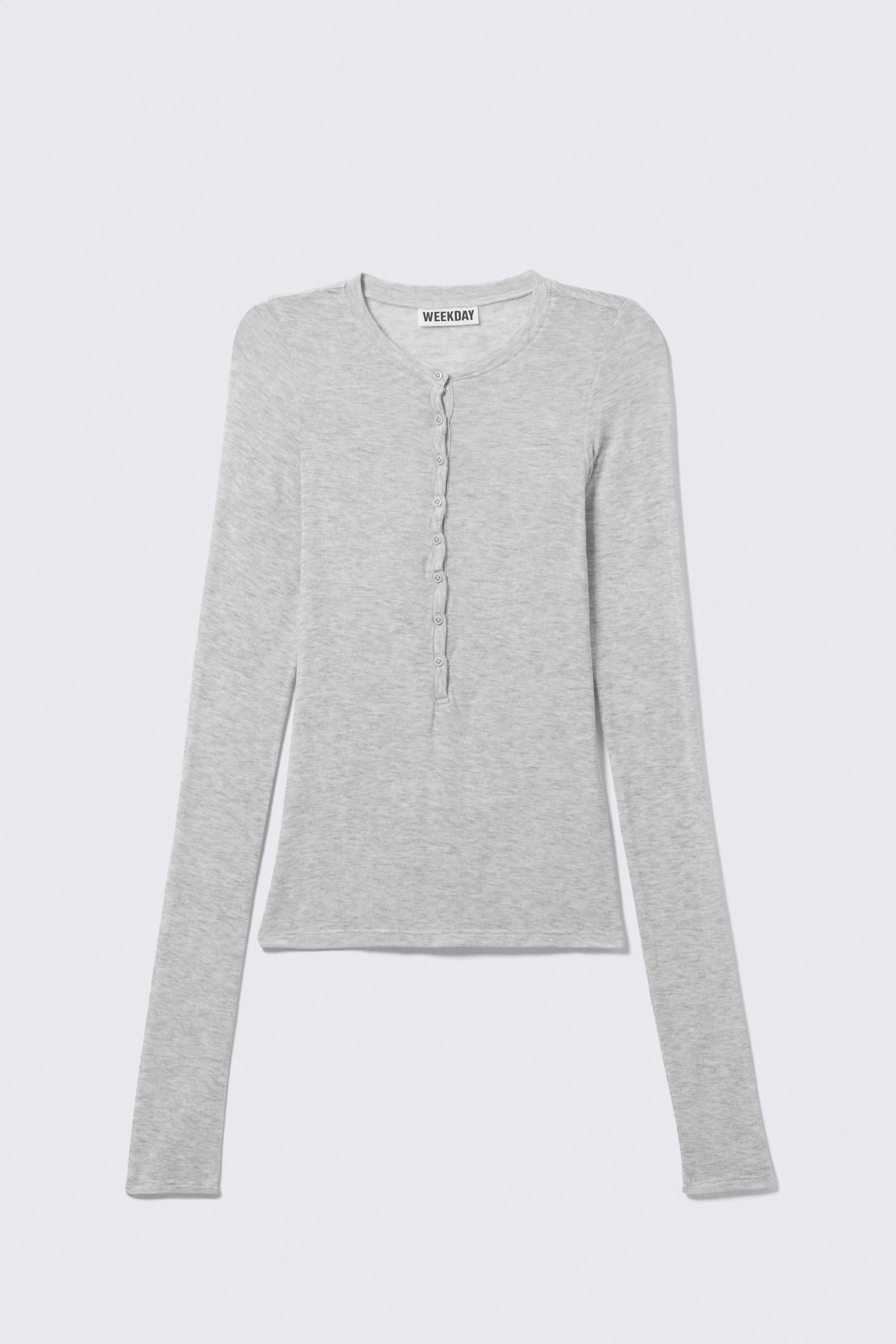 View larger image: A light grey, slim-fitting long-sleeved Henley top is displayed from the FRONT. It features a round neckline with an eight-button placket, slightly longer sleeves with straight cuffs, and a straight hem.