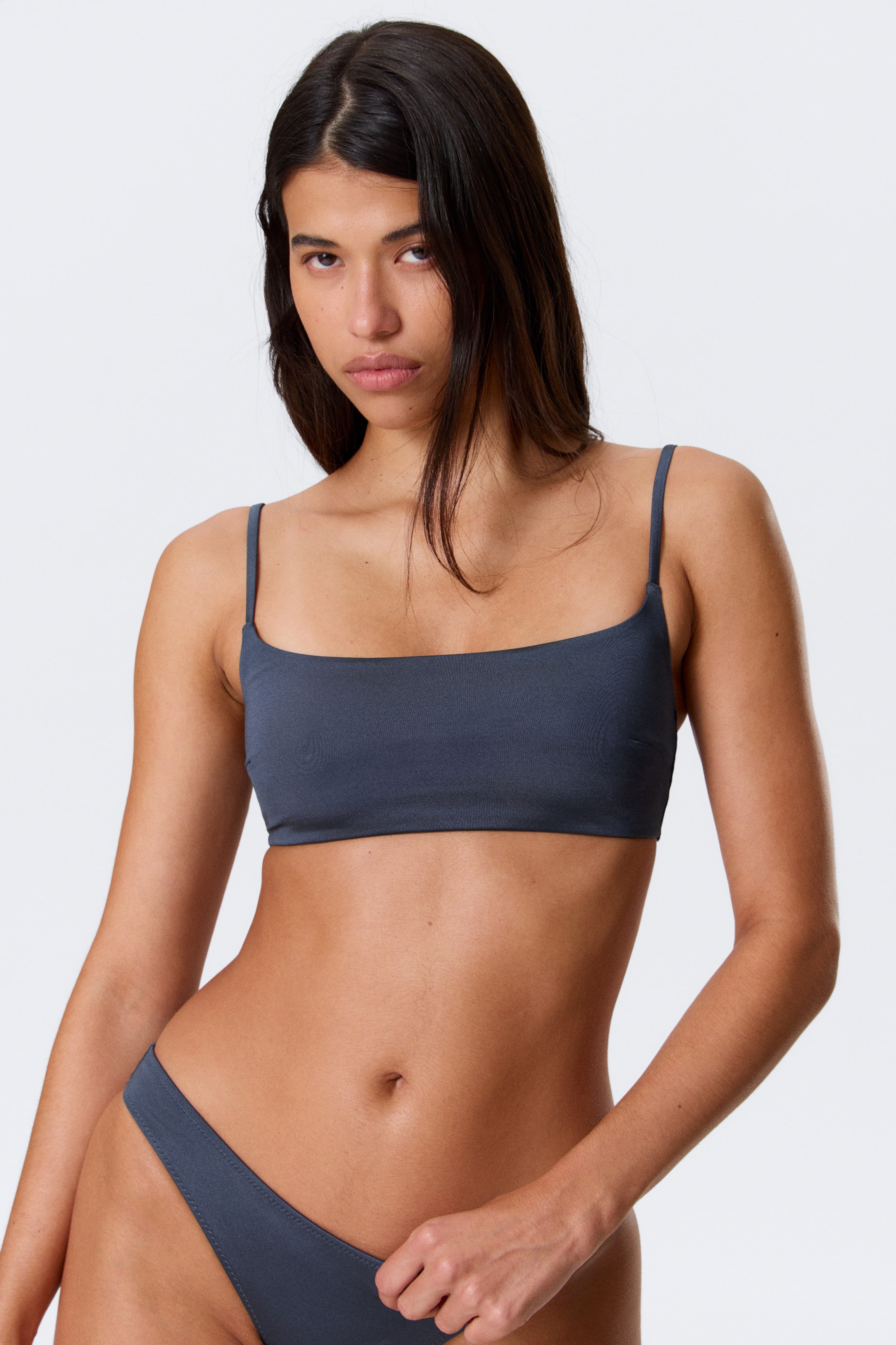 Visualizza immagine più grande: Un top bikini a collo quadrato grigio scuro con spalline sottili viene presentato, abbinato a uno slip bikini grigio scuro coordinato. Entrambi i pezzi aderiscono perfettamente al corpo, mettendo in risalto il loro design.