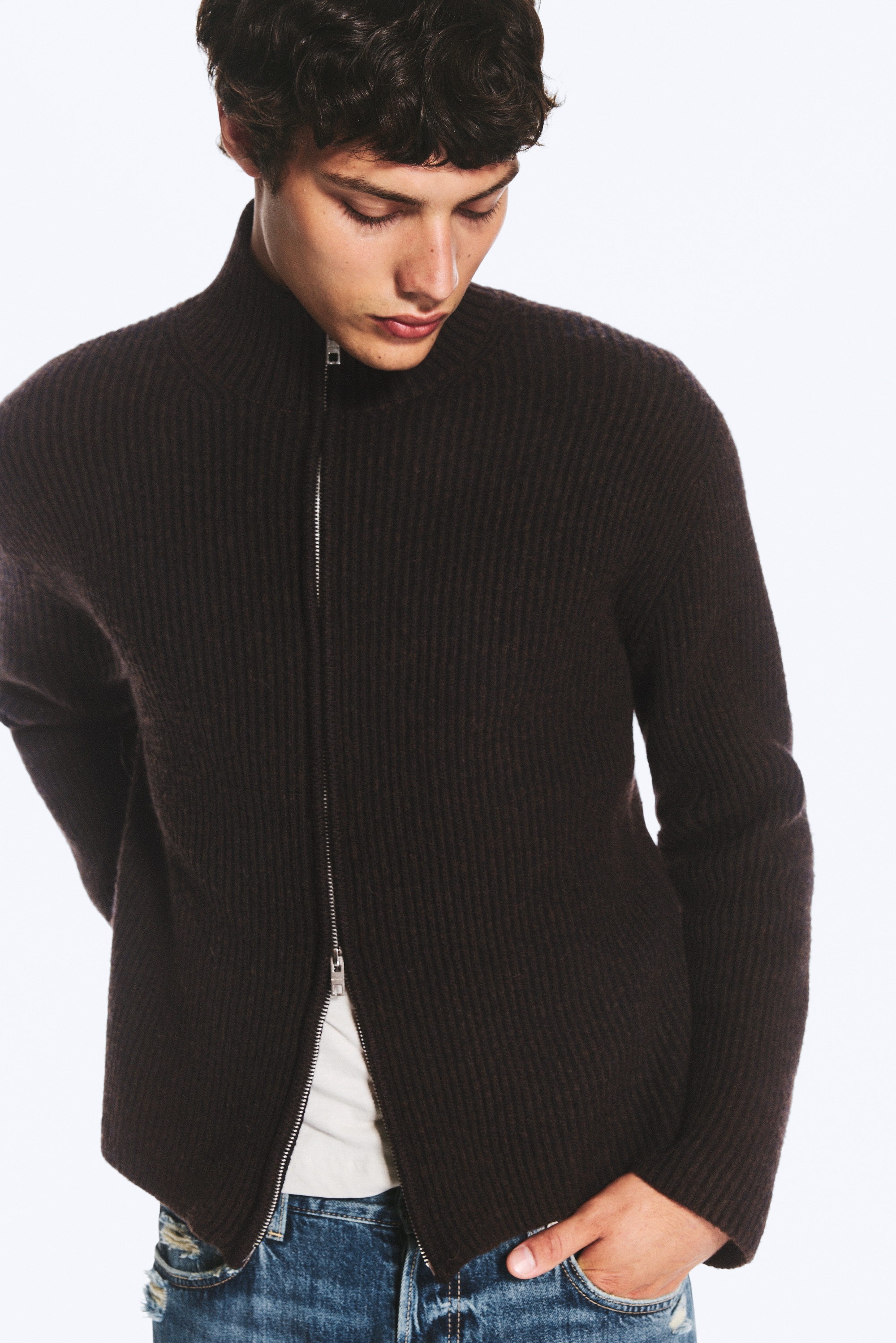Relaxed wool-blend cardigan is facing front, showcasing a dark brown ribbed-knit texture, a high funnel neck, and a silver two-way zip running down the centre.