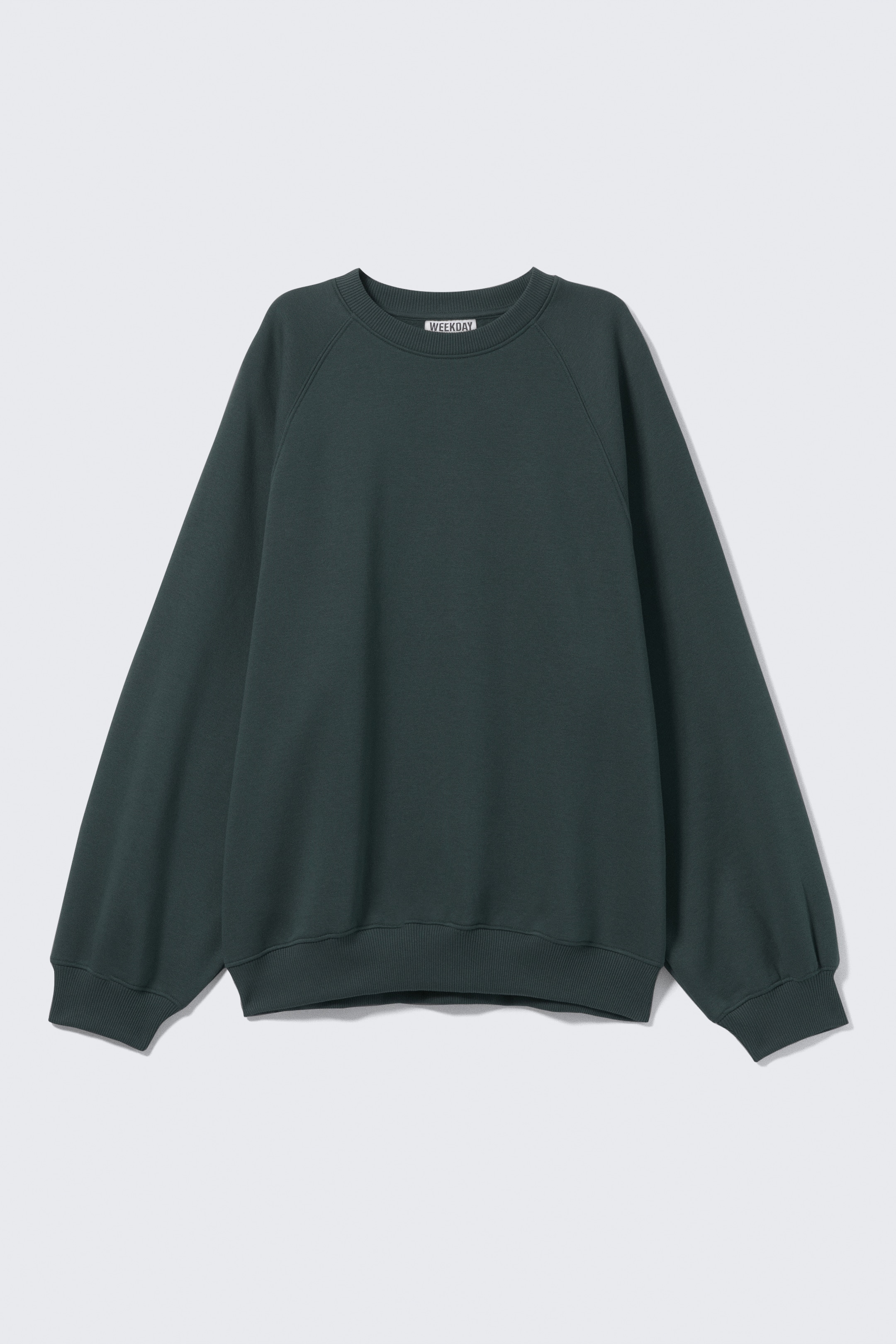 View larger image: A dark green sweater is presented FRONT, laid flat. It is featuring a ribbed crewneck, roomy raglan sleeves, and ribbed cuffs and hem, contributing to a loose, slightly puffy silhouette.