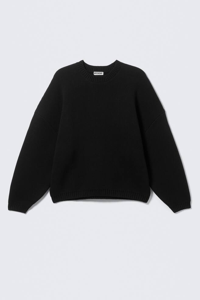 A black knitted jumper is showcasing its FRONT, featuring an oversized fit with dropped shoulders, a crew neck, and ribbed trims at the neck, cuffs, and hem. A white 'WEEKDAY' label is visible at the inner crew neck. - 1