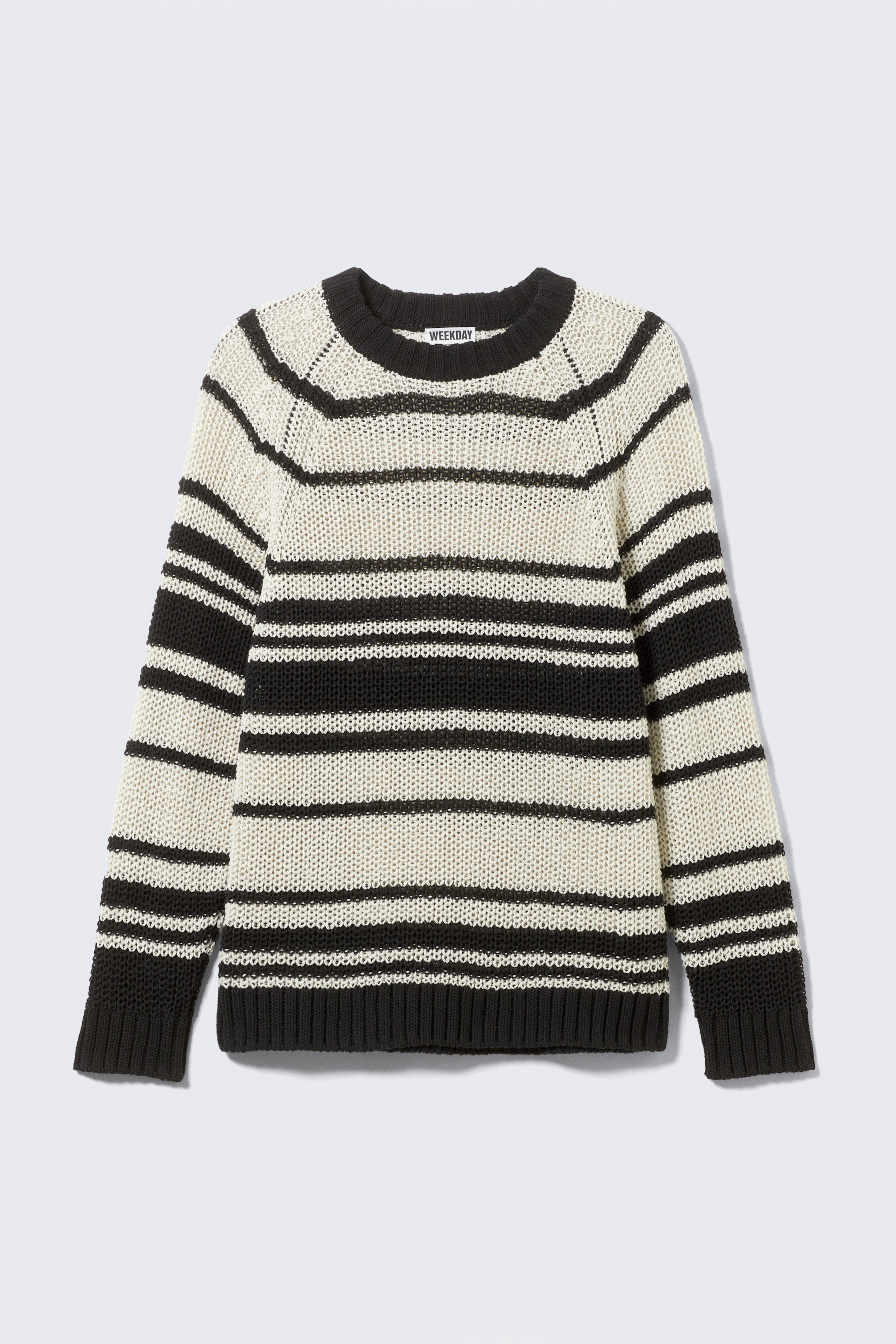 Größeres Bild ansehen: Ein gestreifter Rundhals-Pullover wird als FRONT präsentiert und zeigt eine entspannte Passform und Raglanärmel. Er ist mit abwechselnden breiten und schmalen Streifen in Creme und Schwarz gestrickt und schließt mit einem breiten gerippten Halsausschnitt sowie doppellagigen gerippten Bündchen und Saum ab.