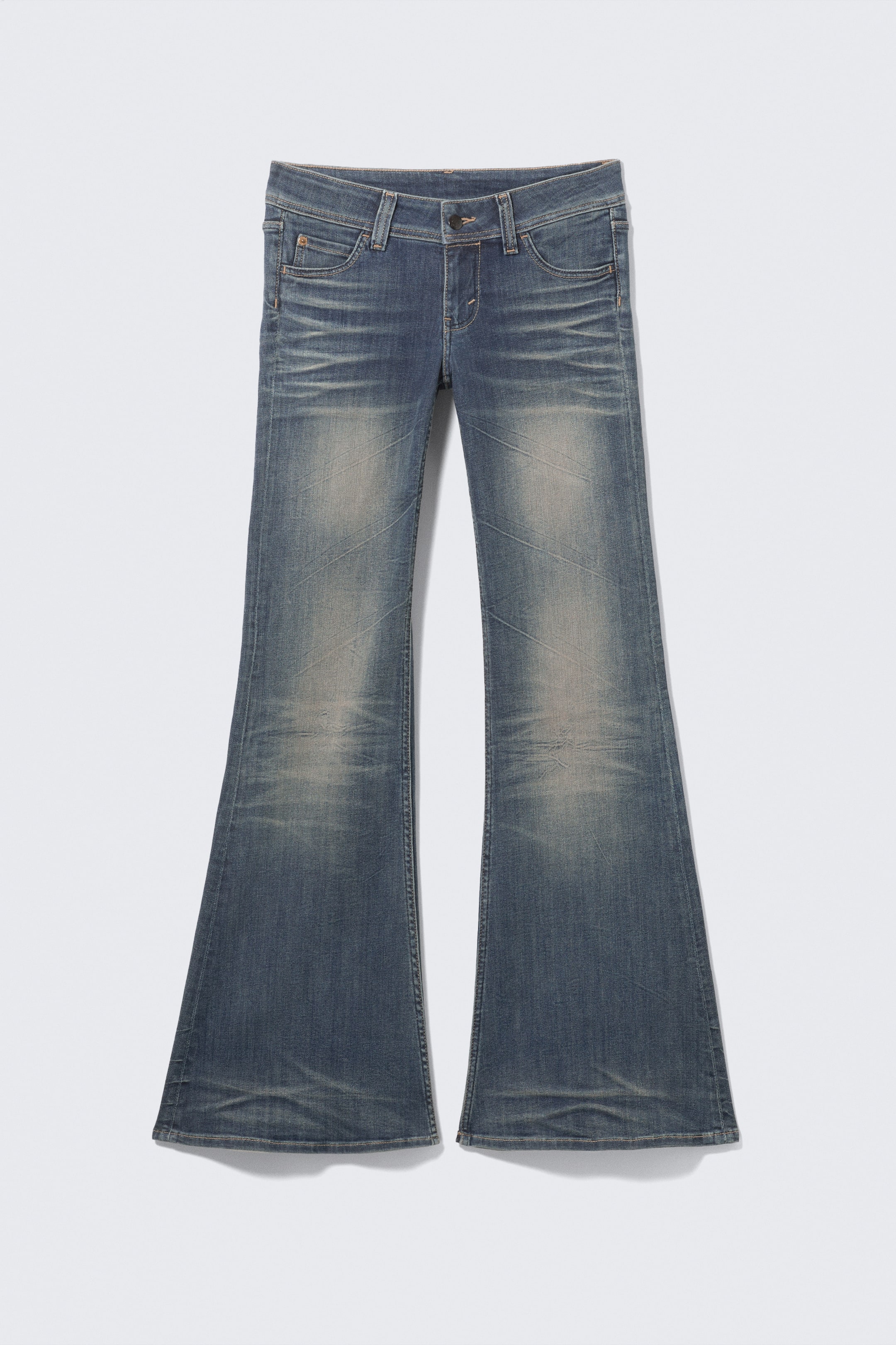 View larger image: A pair of blue denim jeans is shown FRONT, featuring a waistband with a button fastening and zip fly, and a pronounced flared leg. The jeans display a faded wash with visible whiskering and three front pockets, including a coin pocket.