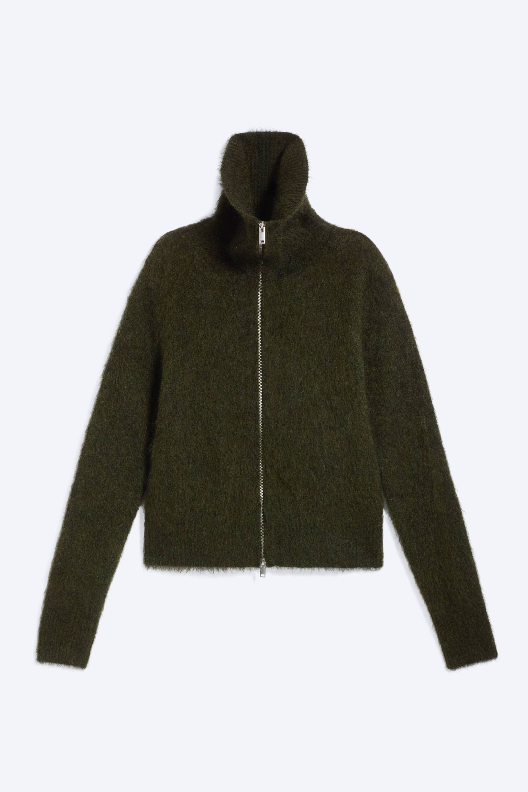 View larger image: A dark green fuzzy jacket featuring a silver full-length zip fastening. It also showcases a high standing collar, long sleeves, and a straight hem.