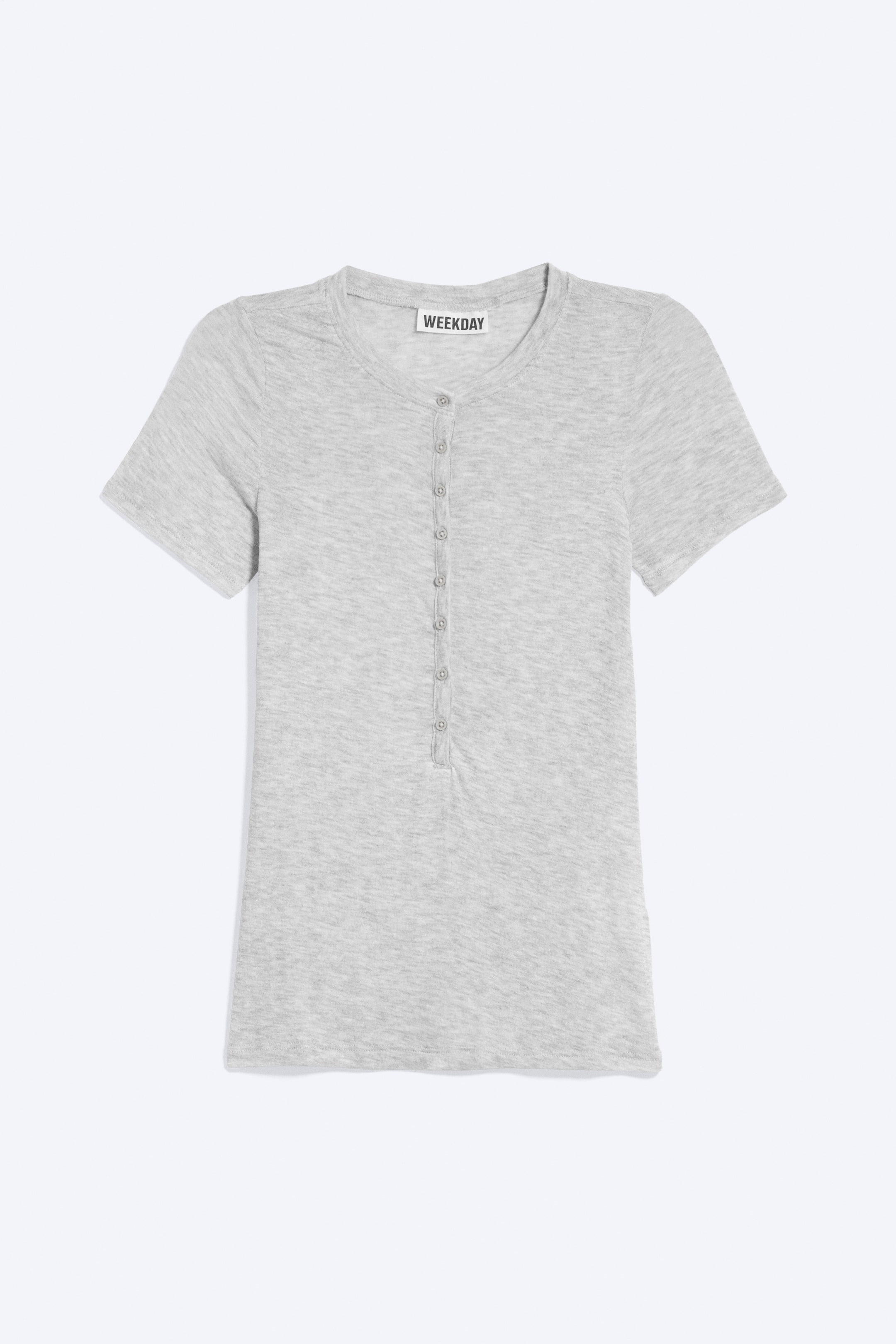 Näytä suurempi kuva: Vaaleanharmaa slim fit henley-paita esitetään edestä, ja siinä on lyhyet hihat ja pyöreä pääntie. Keskellä edessä kulkee pitkä puoliksi napitettava lista, jossa on kahdeksan tummaa nappia meleeratulla neuloksella.