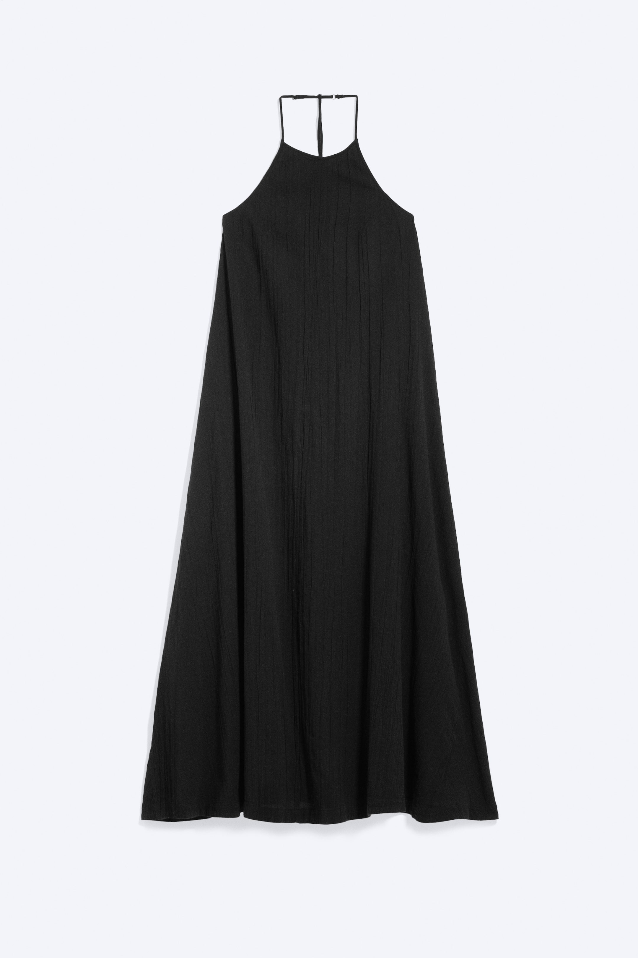 Vezi imaginea mai mare: O rochie maxi neagră prezintă un decolteu halter și o siluetă fluidă în formă de A. Este dotată cu bretele subțiri tip spaghetti care se unesc în partea superioară a spatelui, iar materialul prezintă o textură subtilă cu pliuri verticale.