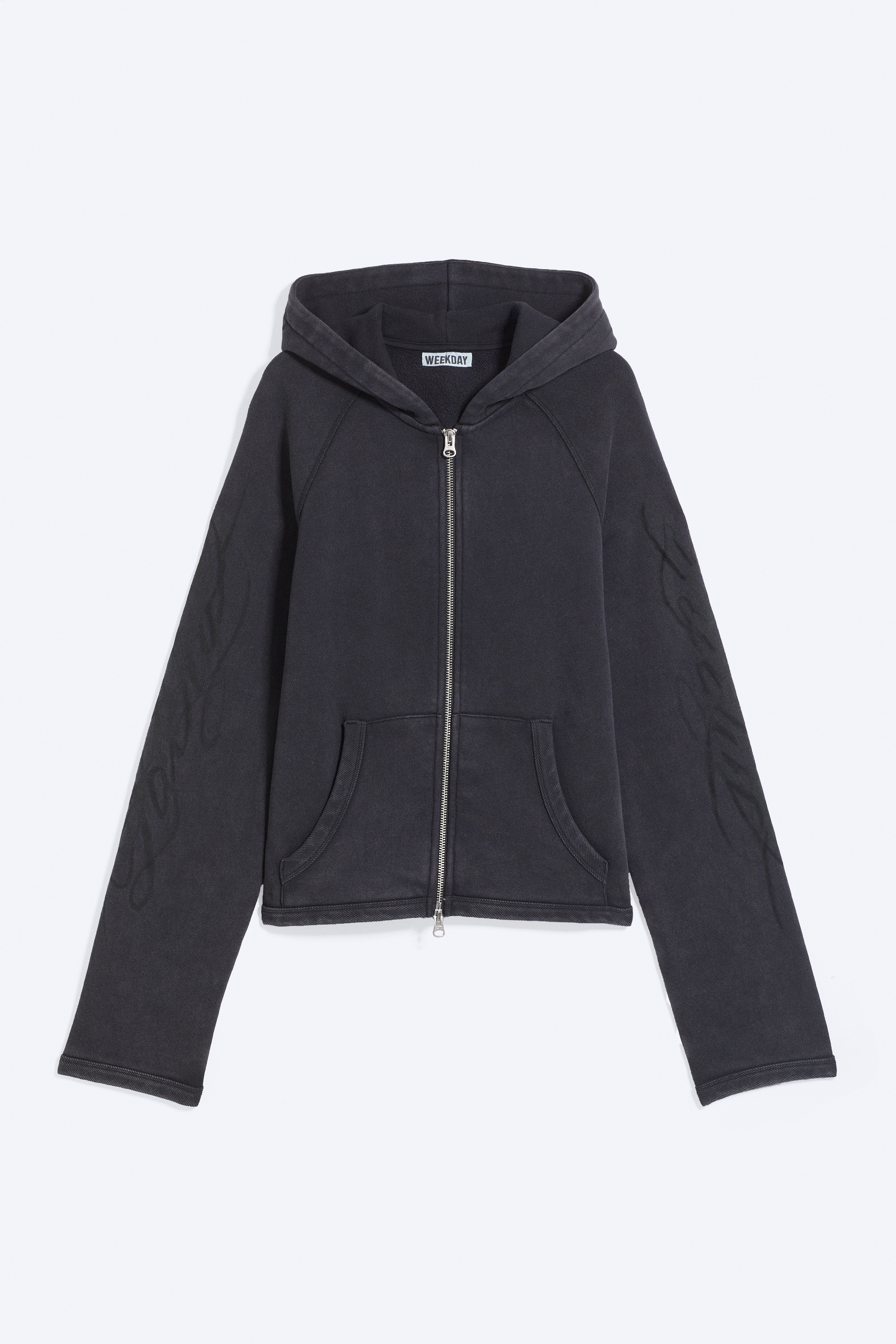 A slim-fit hoodie in a faded dark purple wash is being worn by the model, viewed from behind. The lowered hood features a black abstract scribble graphic printed across the fabric.