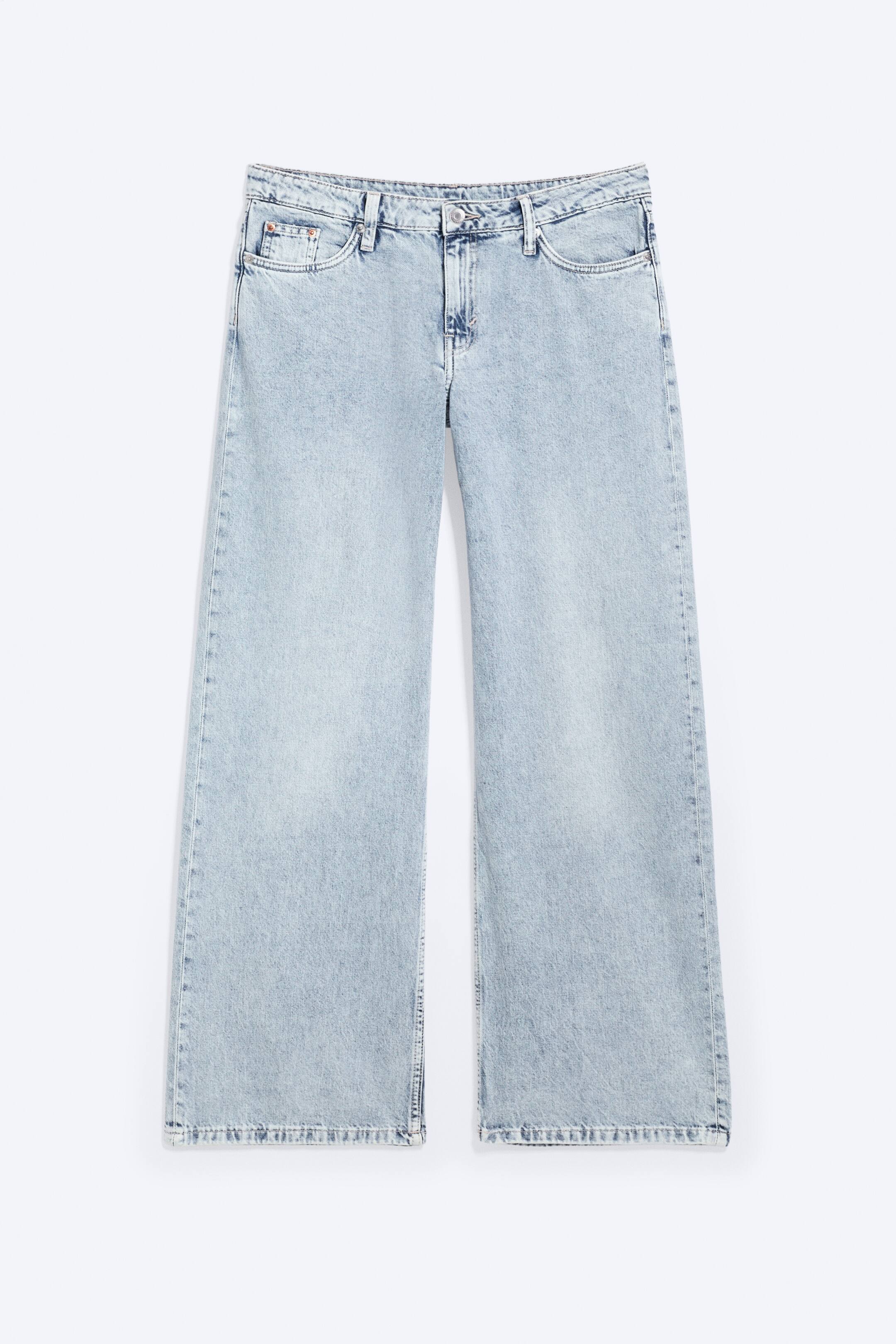 Visualizza immagine più grande: Un paio di jeans in denim rigido, lavaggio chiaro e sbiadito, presenta una vestibilità a vita bassa, ampia e a gamba larga, con lunghezza completa e vista frontale. Sono caratterizzati da una cintura con passanti per cintura e chiusura con bottone, insieme a due tasche frontali e una tasca portamonete.