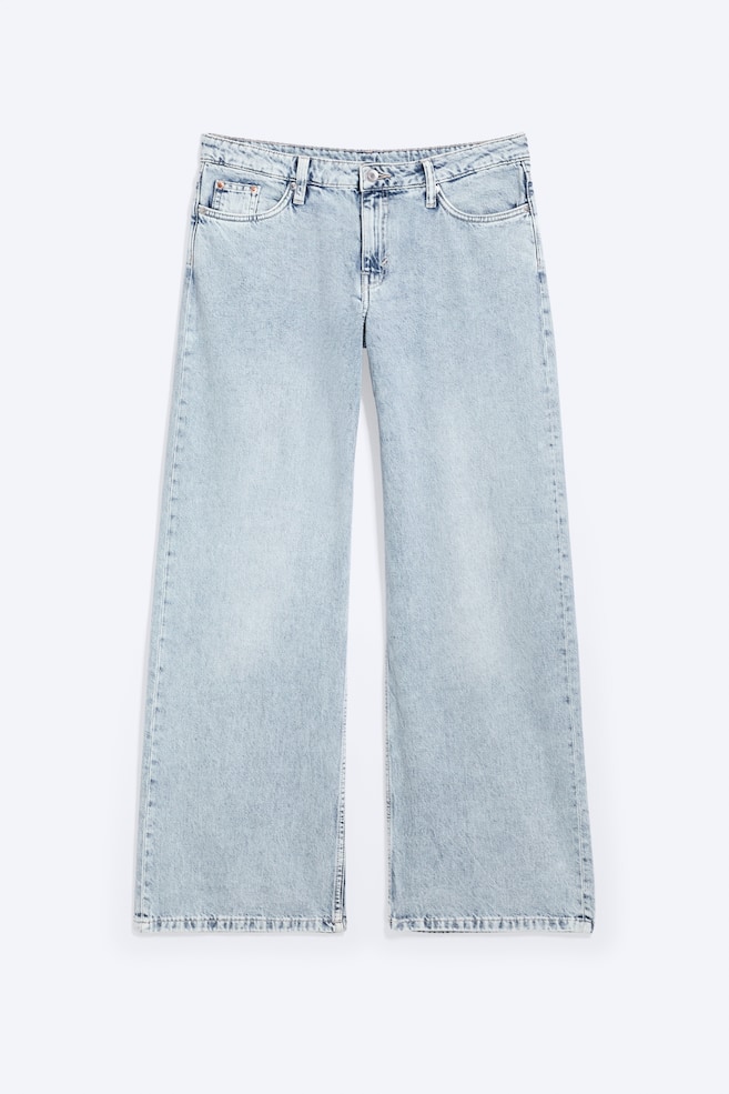A pair of light blue, faded wash, rigid denim jeans is presenting a low-rise, loose, wide-leg, and full-length fit, with the front facing. They feature a waistband with belt loops and a button fastening, along with two front pockets and a coin pocket. - 1