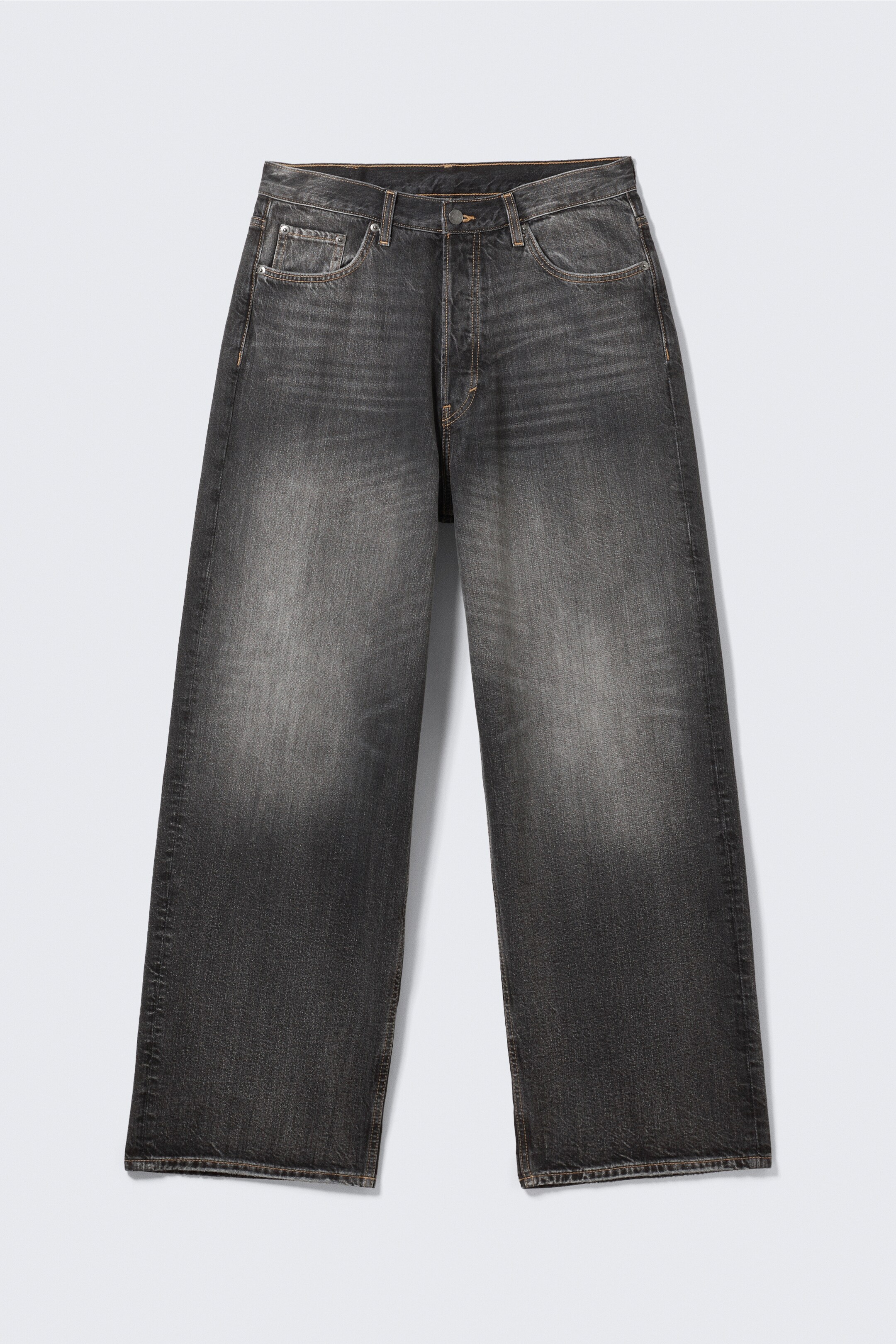 Grösseres Bild ansehen: Eine locker sitzende Jeans, von vorne gesehen, zeigt ein gewaschenes schwarzes Denim mit verblassten Bereichen an den Oberschenkeln, einem weiten Bein und einer langen Länge. Die Jeans sind im klassischen 5-Taschen-Stil gestaltet, einschließlich sichtbarer Vorder- und Münztaschen, und verfügen über einen Knopfverschluss.