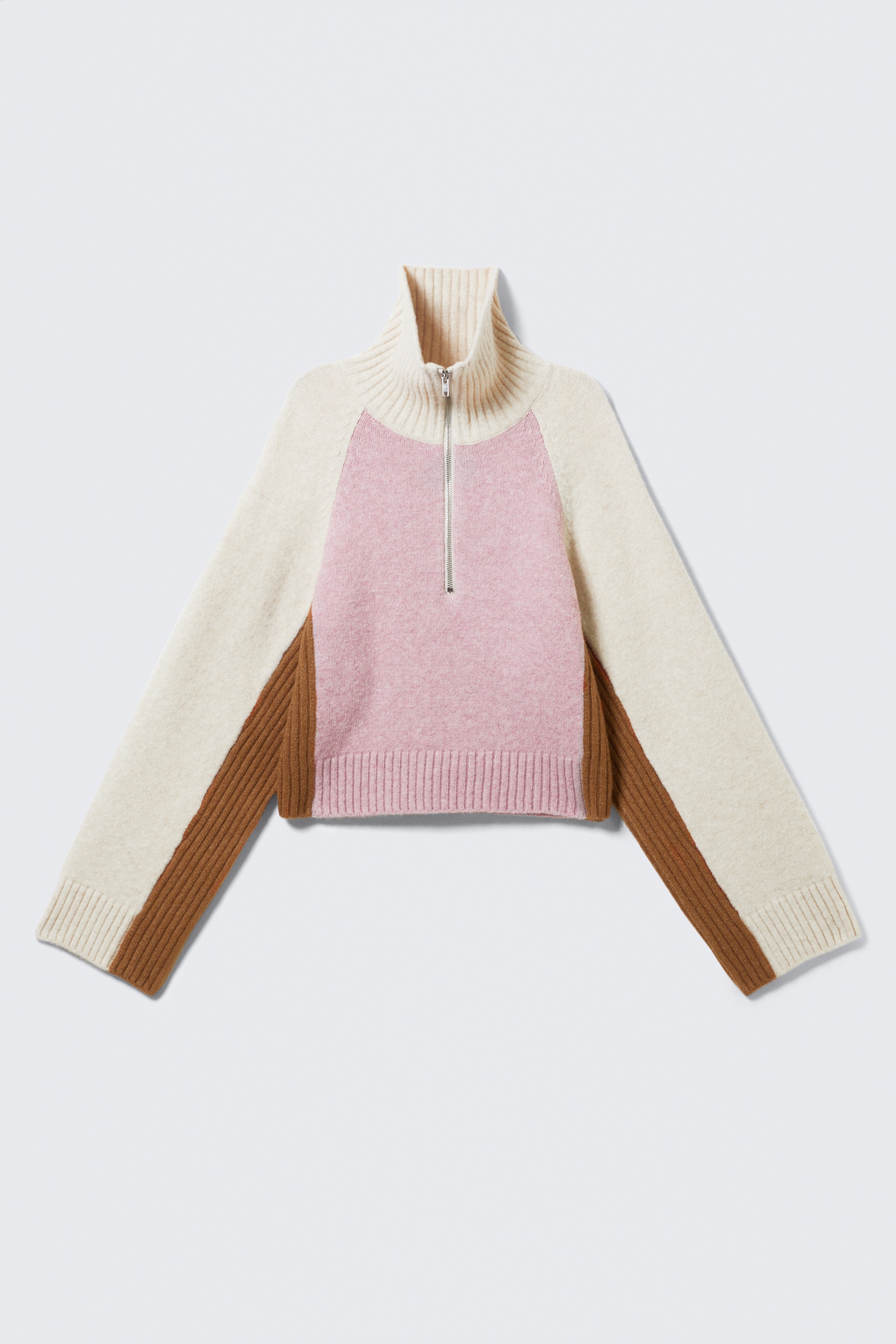 Grösseres Bild ansehen: Ein Half-Zip-Pullover präsentiert sich auf der FRONT, mit einem kurzen, kastigen Schnitt und einem color-blocked Design. Auf der Vorderseite ist ein rosafarbener Einsatz zu sehen, cremefarbene Raglanärmel und braune Seitenteile, die sich bis zu den Ärmeln erstrecken, wobei die braunen Abschnitte eine markante Rippstrickstruktur präsentieren. Ein silberfarbener Half-Zip-Verschluss befindet sich auf der Vorderseite, während grobe Rippdetails den cremefarbenen Kragen, die cremefarbenen Bündchen und den rosafarbenen Saum abschließen.