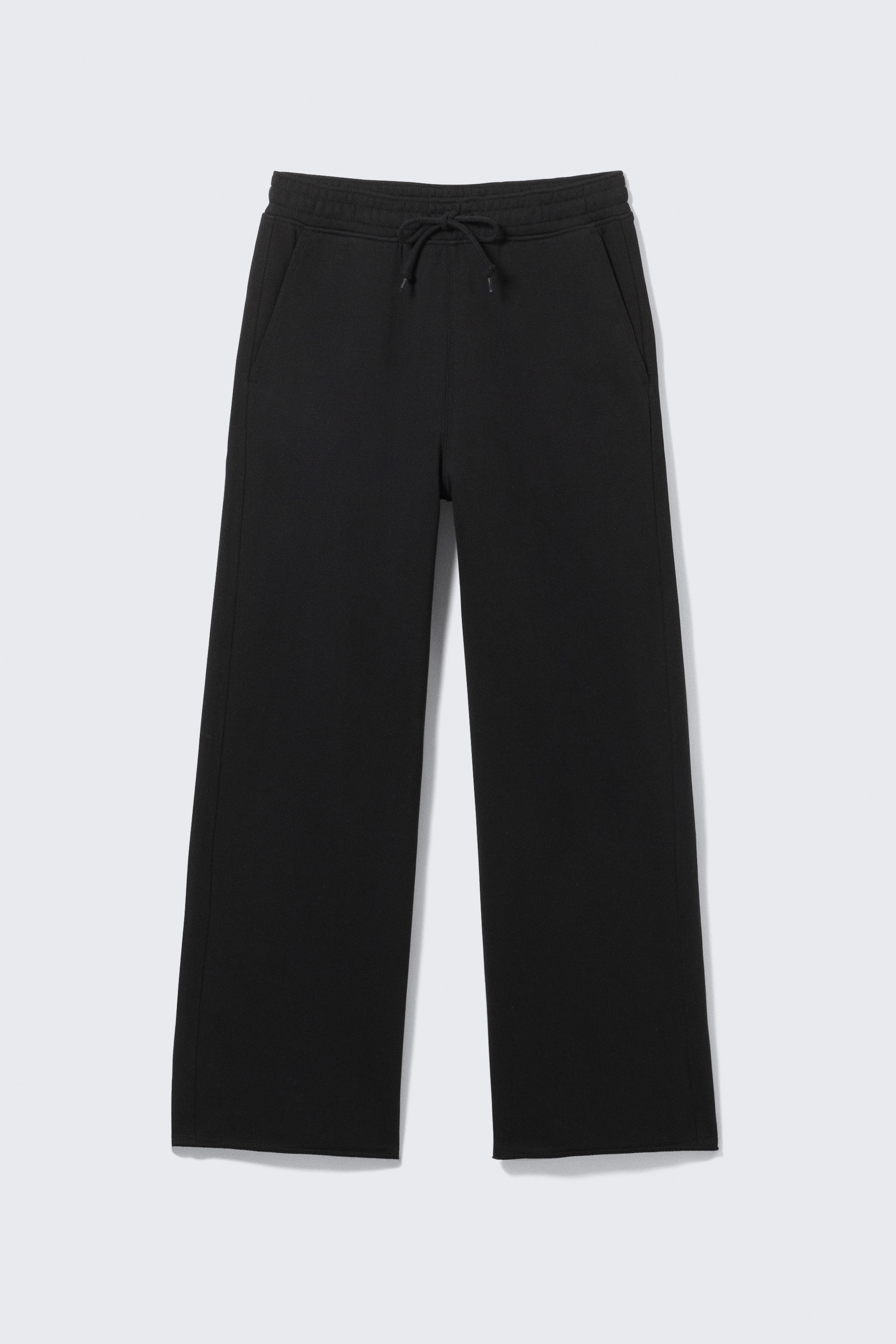 Visualizza immagine più grande: I pantaloni della tuta neri a gamba larga sono mostrati FRONTE, con una larga cintura con coulisse annodata e tasche laterali inclinate. Gli orli appaiono non rifiniti.