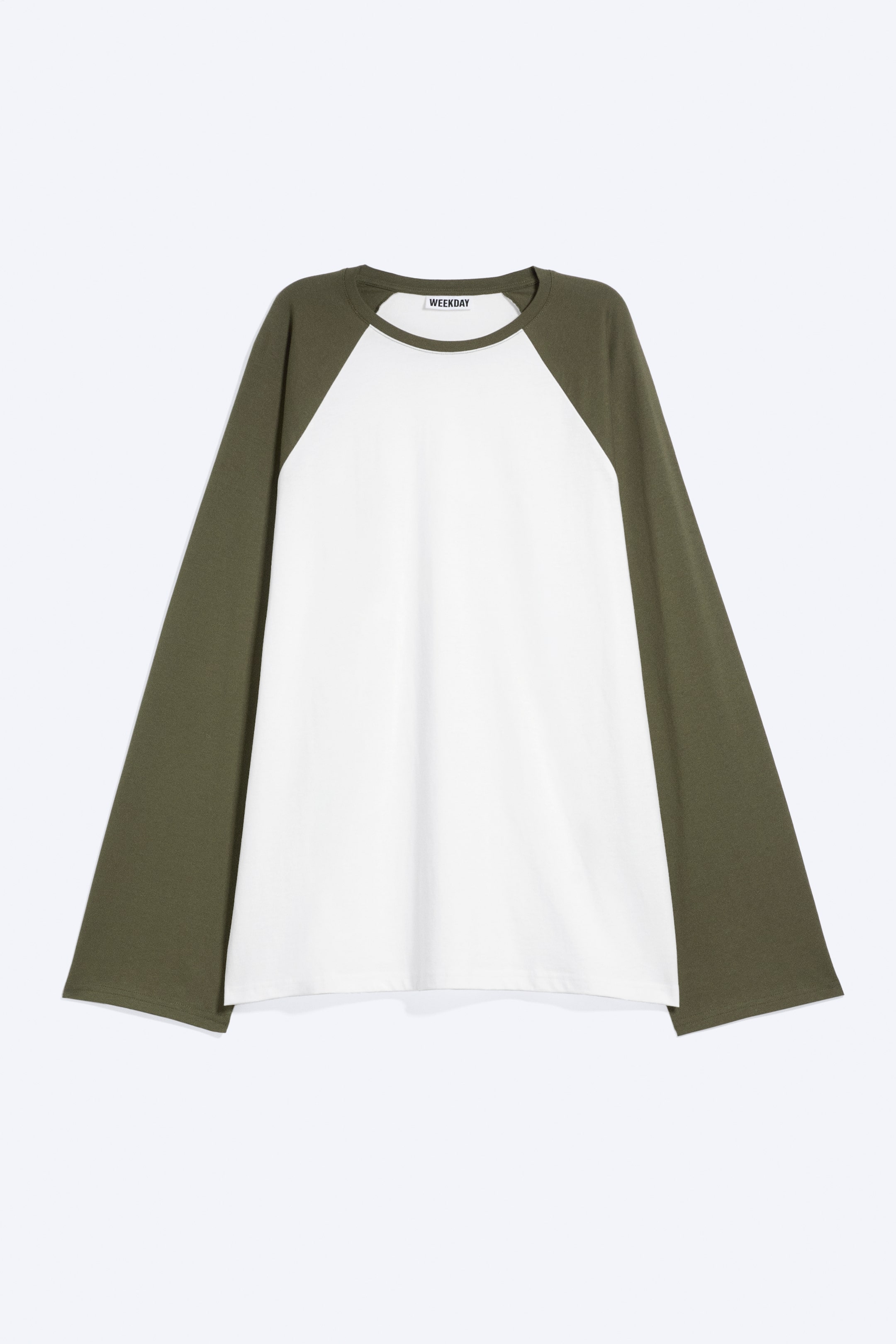 View larger image: A loose raglan long-sleeved top is facing front, featuring a white bodice and contrasting olive-green raglan sleeves. The top features a crew neckline with a matching olive-green trim and loose, wide-cut cuffs.