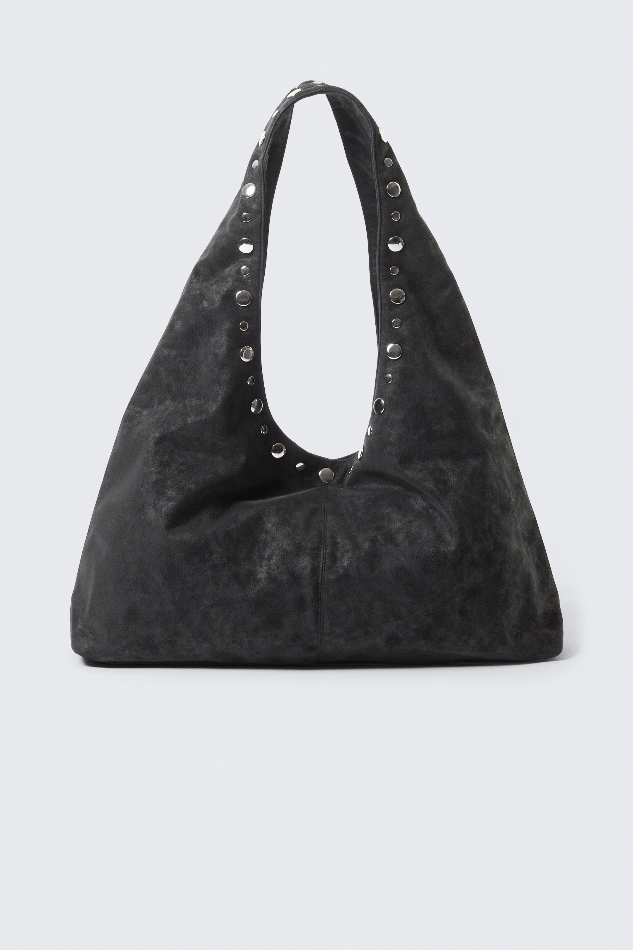 Agrandir l'image: Un sac à bandoulière sombre et décontracté est présenté de FACE, avec une silhouette triangulaire douce et un volume sculptural. Il est fabriqué à partir d'un cuir synthétique texturé avec une finition douce, et sa poignée supérieure incurvée est ornée de nombreux œillets en métal argenté.