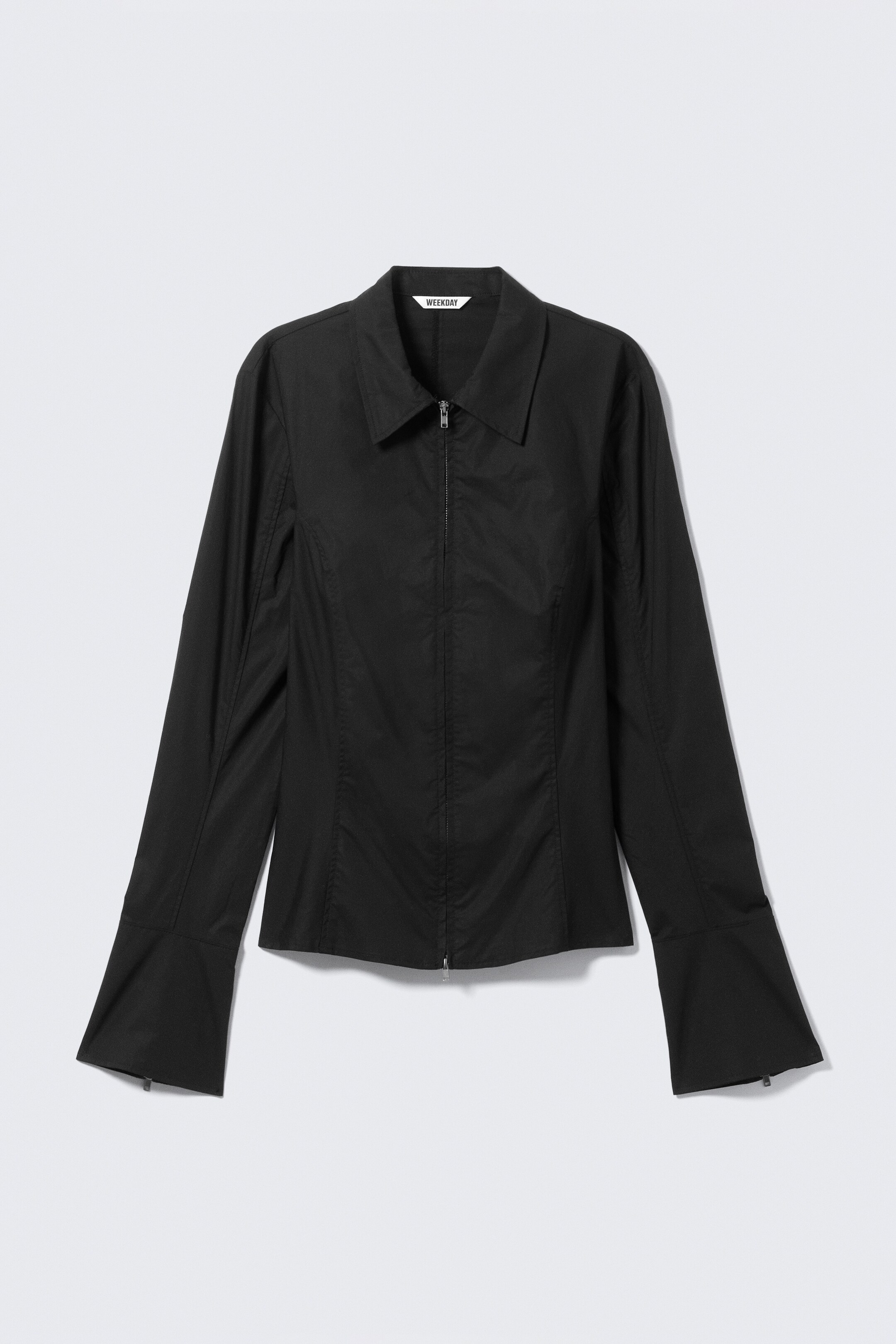 Visualizza immagine più grande: Una camicia nera aderente è presentata FRONT, con un colletto affilato, una cerniera a doppio verso al centro, e cuciture modellate verticalmente. È caratterizzata da maniche lunghe, ampie e svasate con sottili tiralampo visibili ai polsini.