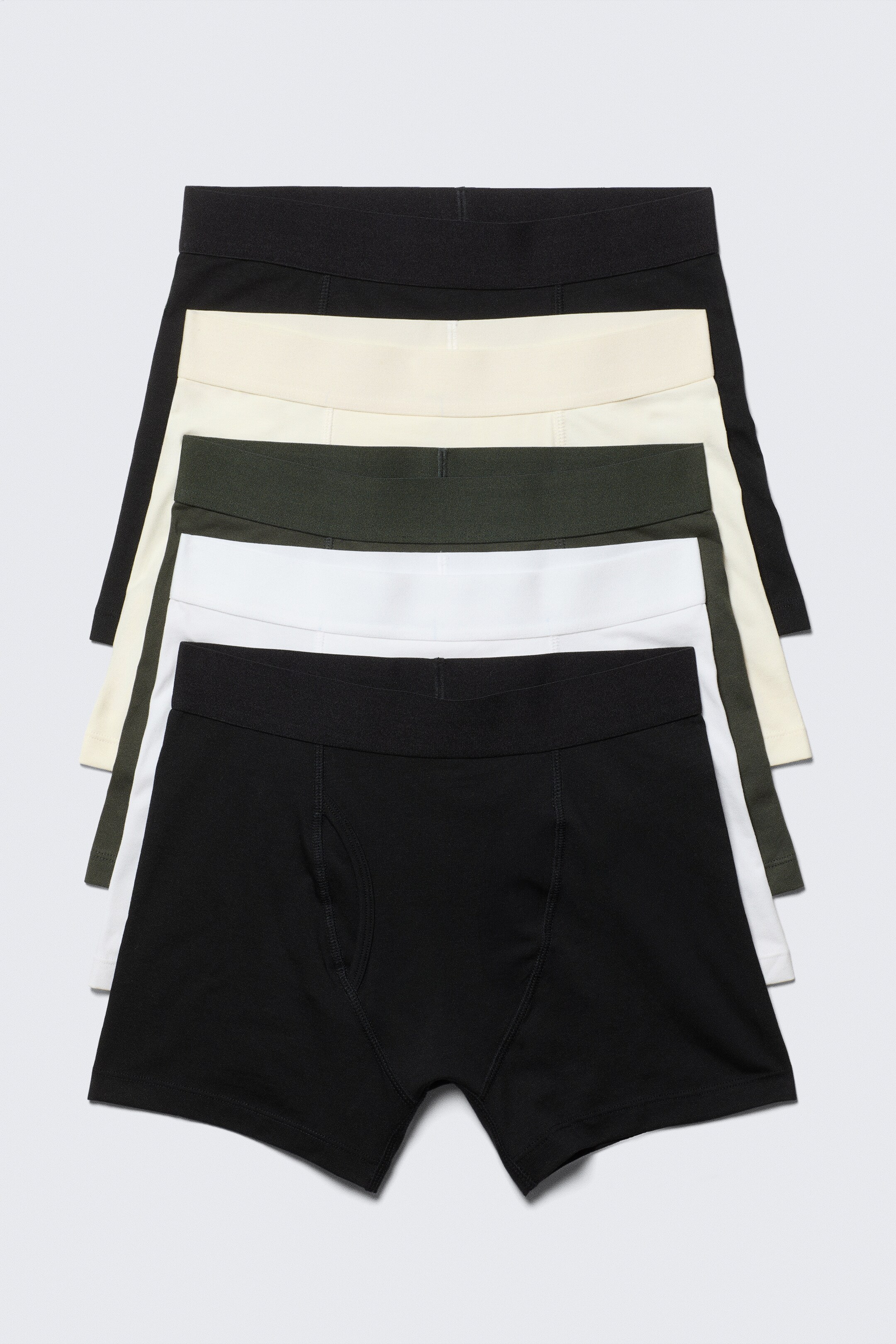 Agrandir l'image: Un paquet de cinq boxers pour hommes est empilé, montrant leur devant. Chaque paire présente une ceinture élastique monochrome et des coutures plates lisses. Les couleurs incluent le noir, le blanc cassé, le vert foncé et le blanc.