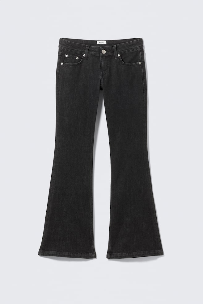 Un pantalon en jean gris foncé est présenté de face, avec une taille basse et une fermeture à bouton visible ainsi qu'un design classique à cinq poches. Le jean présente une coupe ajustée au niveau de la cuisse qui s'évase pour former une large jambe. - 1