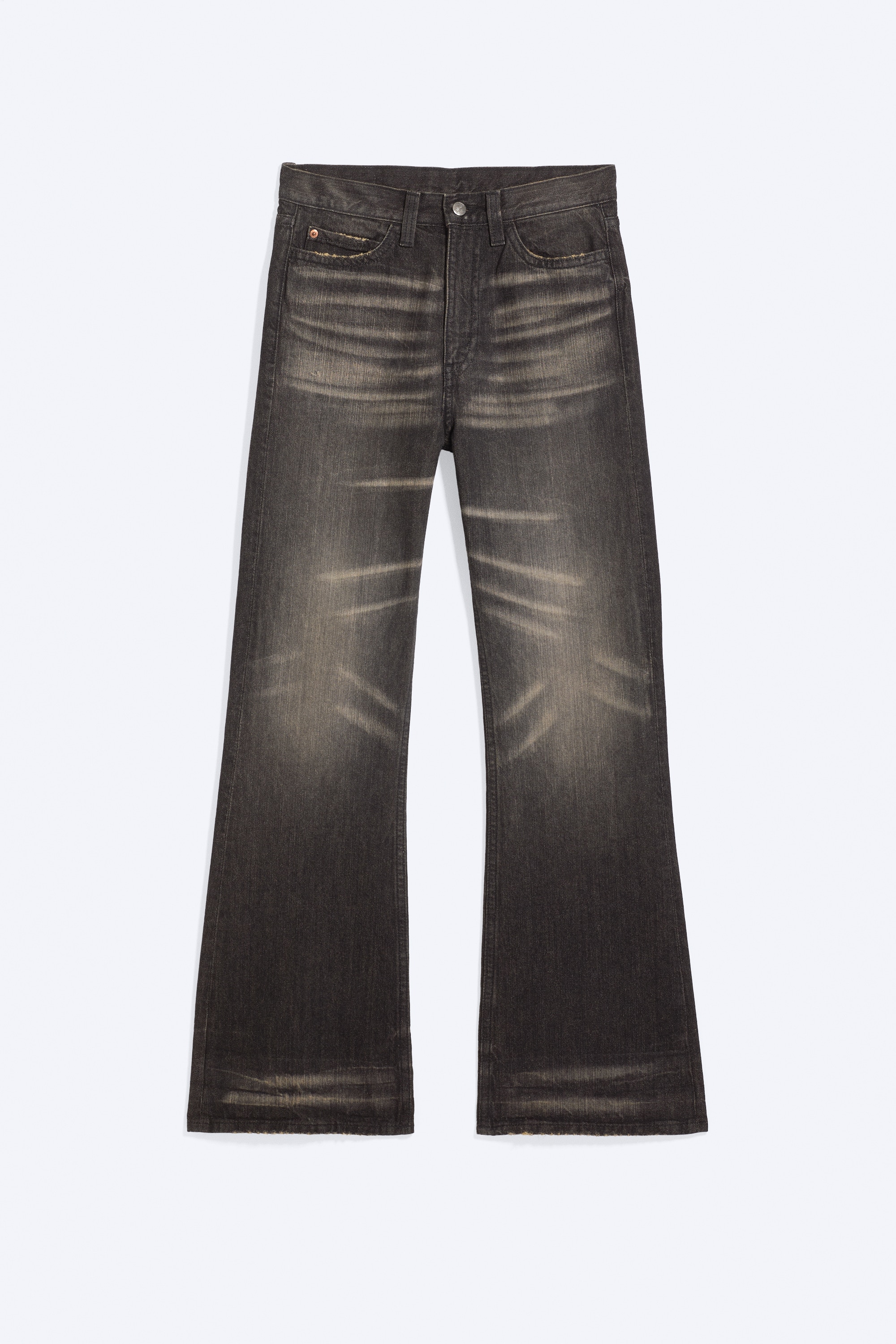 Ein schwarzes T-Shirt mit kurzen Ärmeln und weißen Schriftgrafiken sowie abgenutzten Details wird mit dunkel gewaschenen Bootcut-Jeans kombiniert, die über ein verblasstes Finish verfügen. Ein schwarzer Nieten-Gürtel hält die Jeans zusammen, und am unteren Ende sind karierte Slip-On-Sneaker sichtbar.