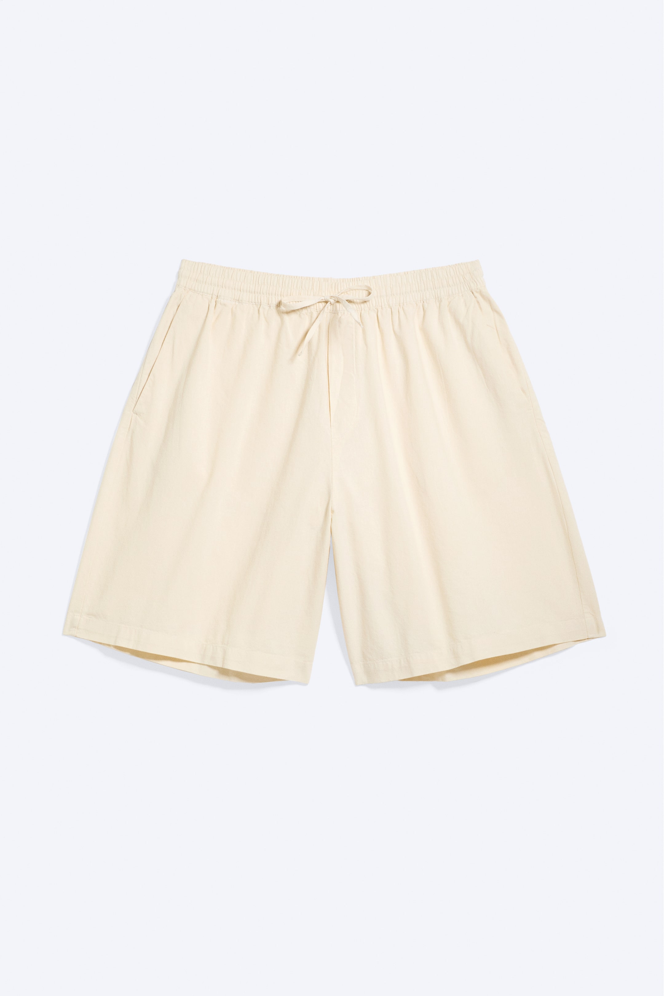 Grotere afbeelding bekijken: Lichtbeige shorts liggen plat en naar voren gericht, met een elastische tailleband met een gestrikte trekkoord en zichtbare zijzakken.