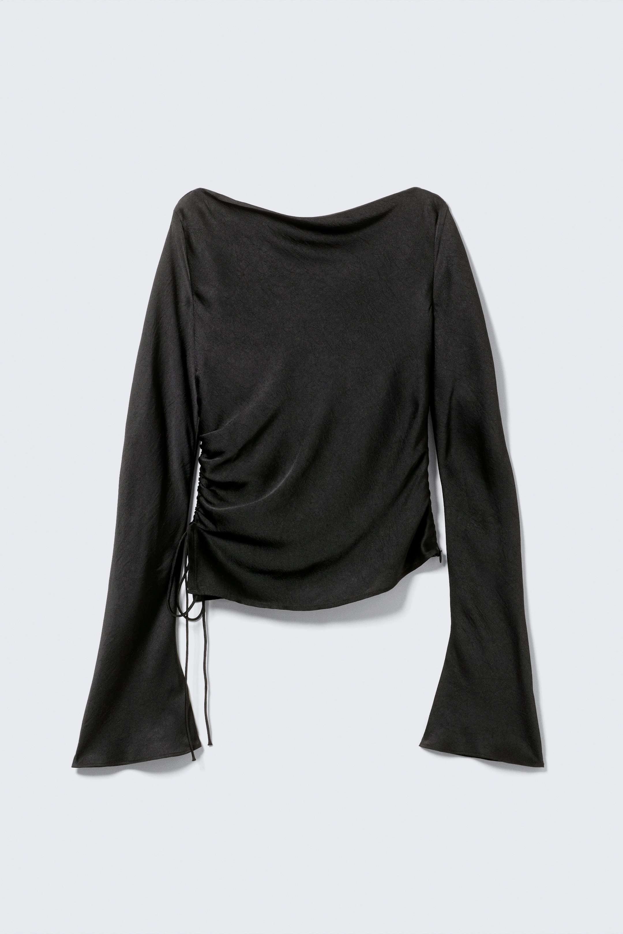 View larger image: A black long-sleeved top, made from a lustrous fabric, is presenting its front view. It is featuring a boat neckline, flared sleeves, and ruching on the left side with visible drawstrings tied at the hem.