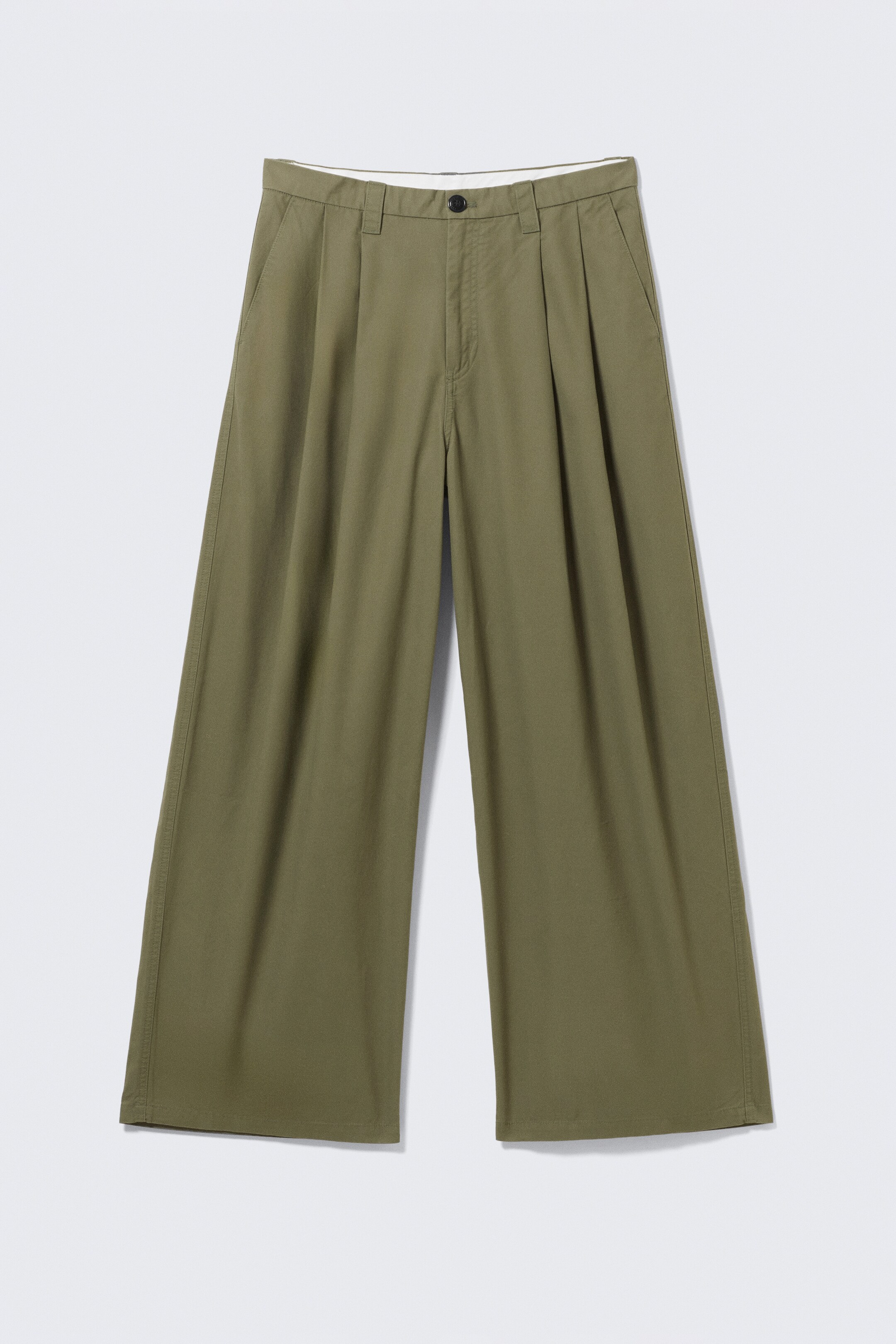 Agrandir l'image: Les chinos surdimensionnés vert olive affichent une silhouette ample et une jambe large, vus de face. Ils présentent des plis à l'avant, des poches latérales en biais, des passants de ceinture et une fermeture éclair avec un bouton supérieur.