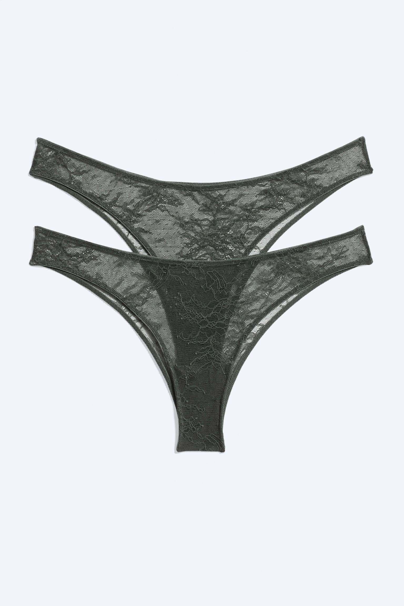 Una confezione da due slip brasiliani in pizzo verde scuro Ã¨ disposta in piano, mostrando il design frontale di entrambi i capi. Entrambi i capi presentano un pizzo floreale trasparente, sottili cinturini laterali e una silhouette a vita bassa a V.