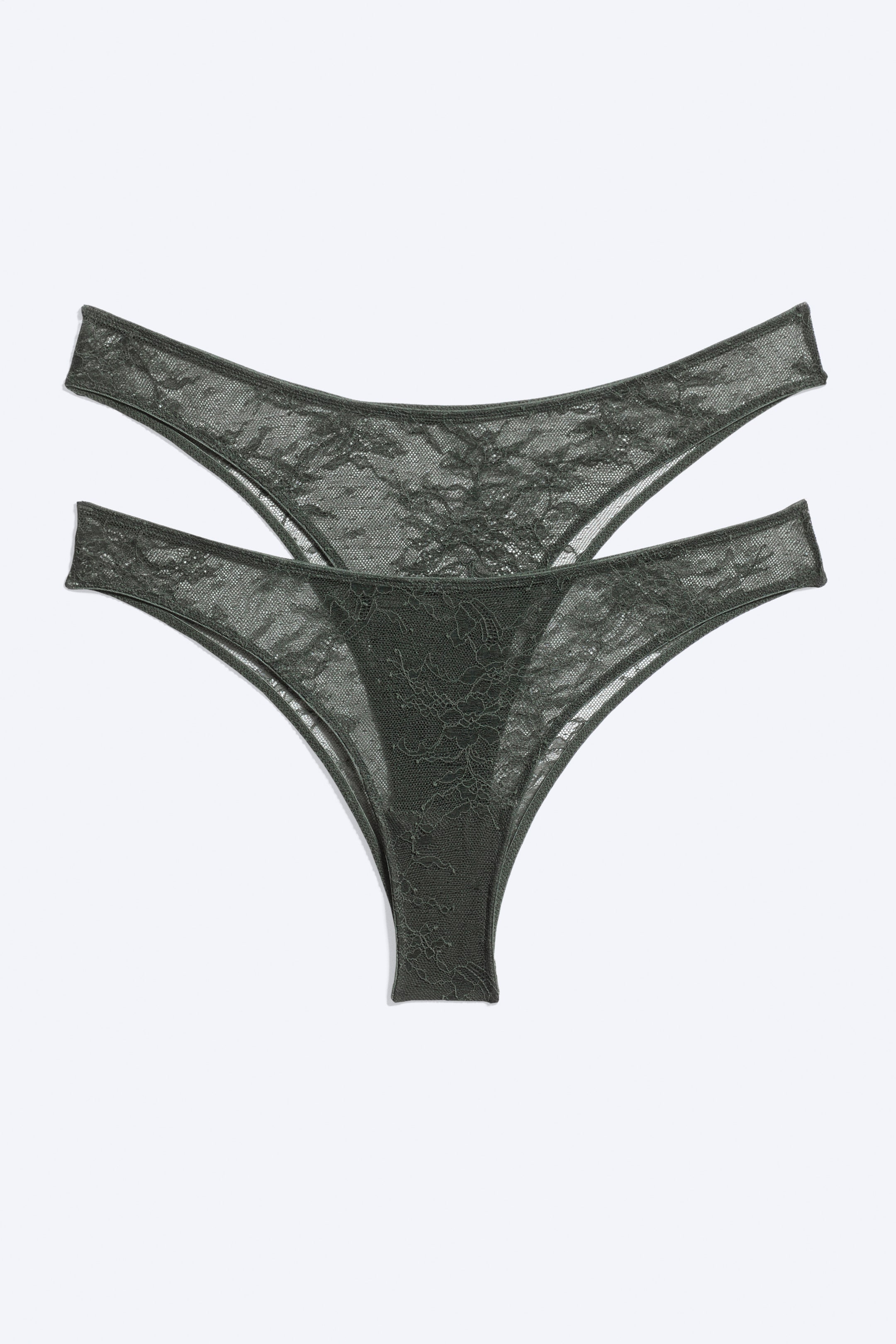 View larger image: A two-pack of dark green lace Brazilian briefs is laid flat, showing the front design of both pairs. Both pairs feature sheer floral lace, thin side straps, and a low-rise, V-shaped silhouette.