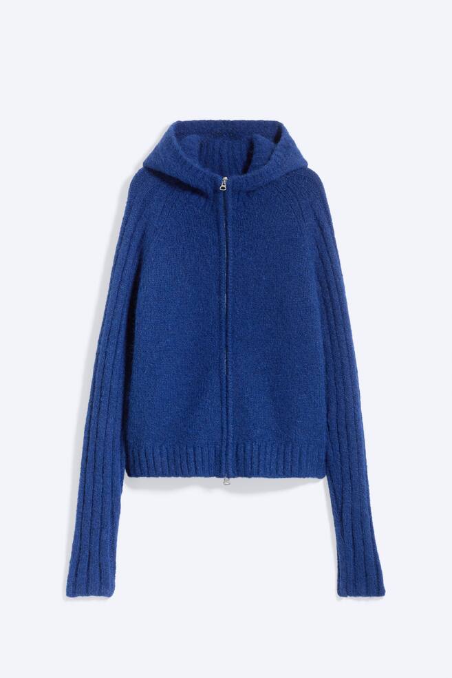 A knitted zip hoodie in royal blue is shown from the front, featuring a full-length front zip fastening and an attached hood. The design showcases a fuzzy, textured knit body, long raglan sleeves with wide vertical ribbing, and a ribbed hem. - 1