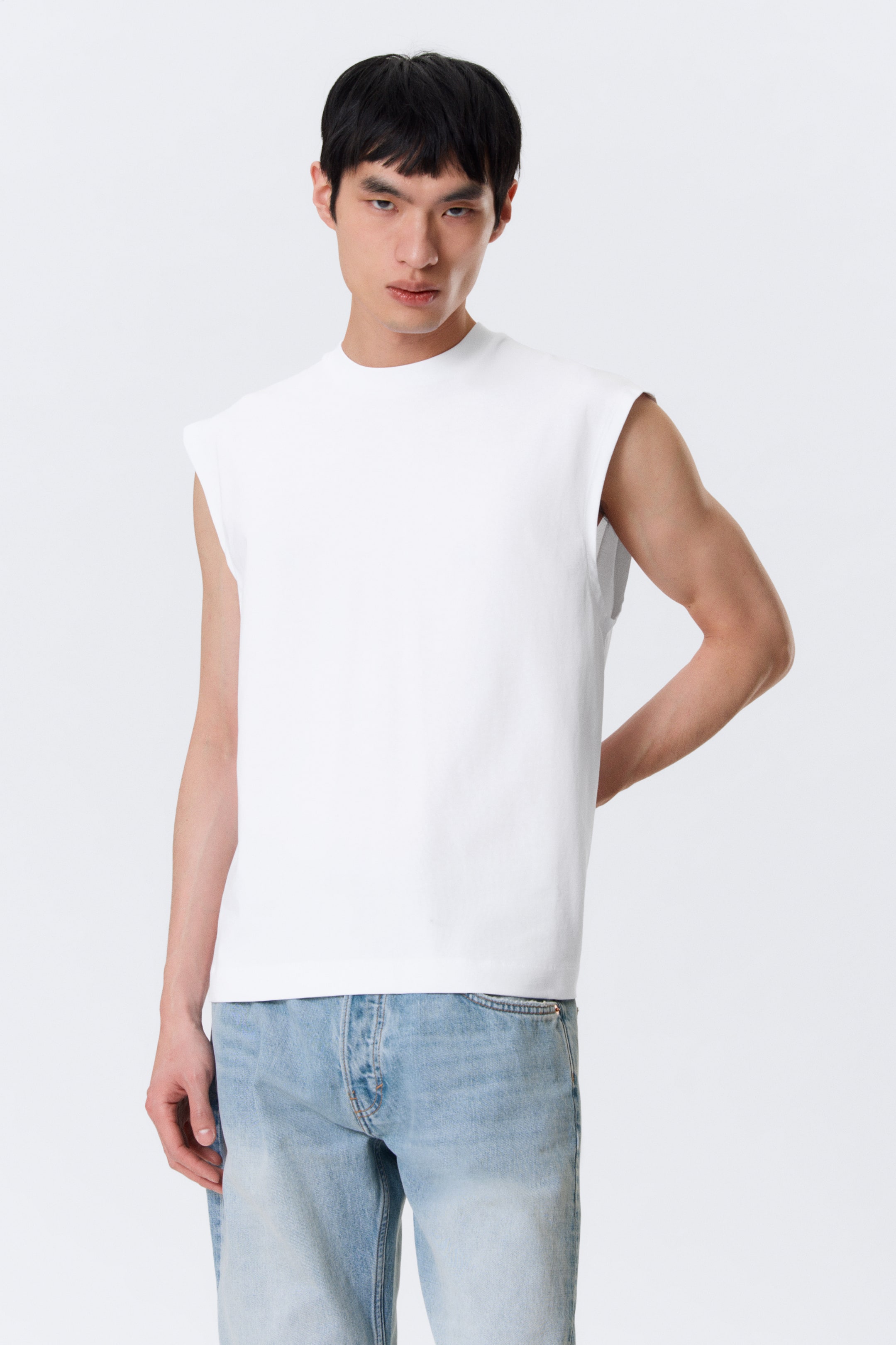 View larger image: A white muscle tee is showcased from the front, featuring a crew neck and a straight hem.