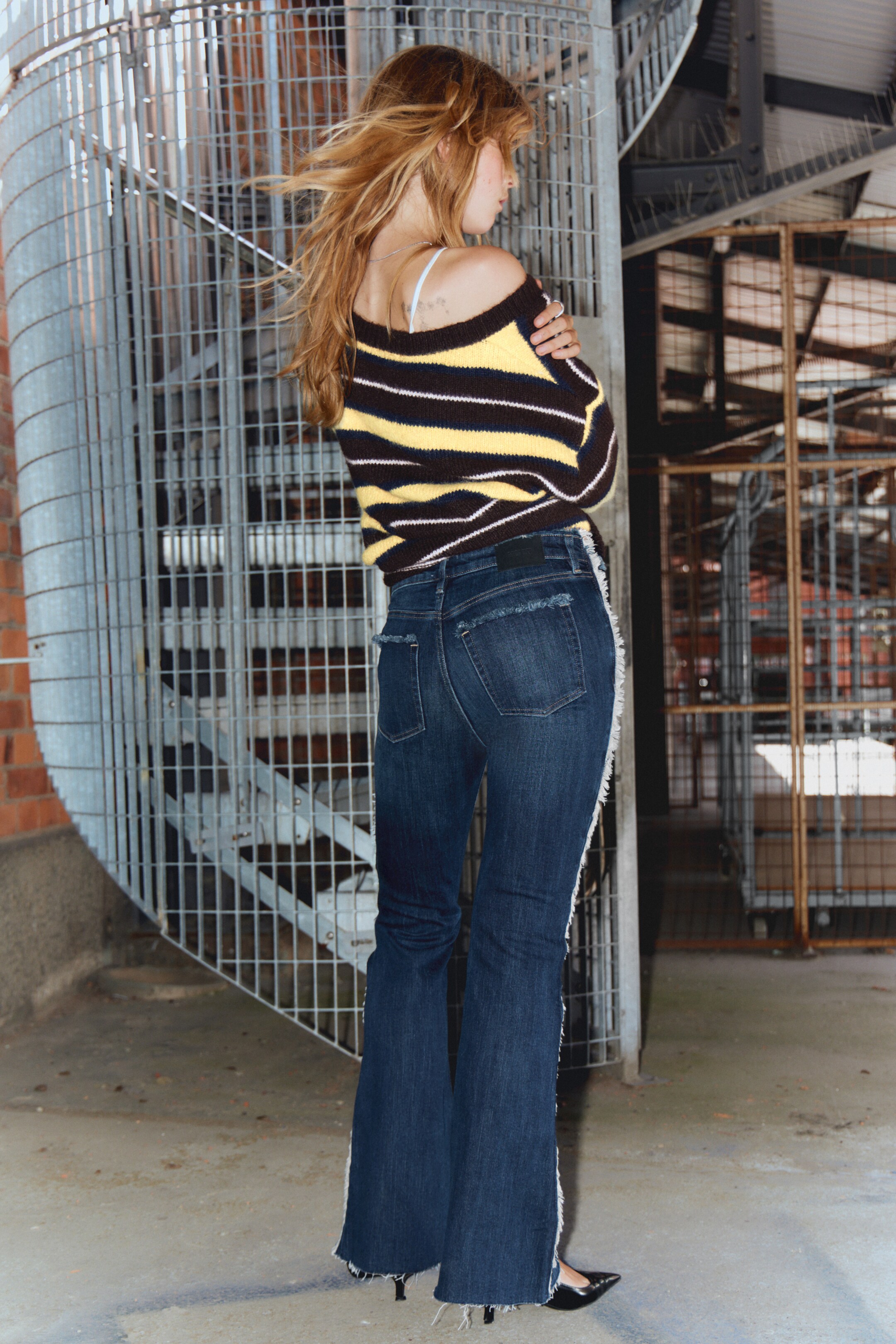 Se større billede: Et par mørke vaskede, slim fit jeans vises bagfra, der fremviser en lav talje og en vid benåbning. De er lavet i komfortstræk denim, med fremtrædende råkantdetaljer ved linningen, sidesømmene og kanten, og de har også en fem-lomme konstruktion med klassisk topstikning.