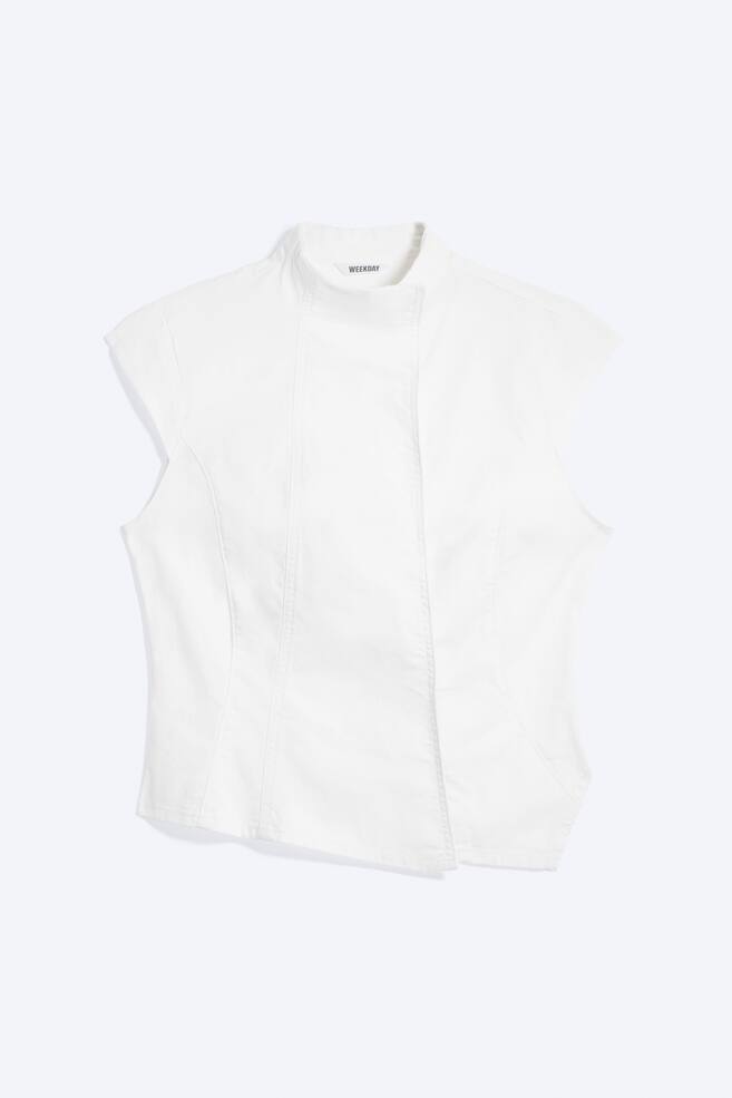 A white fitted short-sleeved top is facing front, featuring a mock neck and a concealed button fastening. Curved seam detailing enhances its structured silhouette, and an asymmetric hem completes the design. - 1