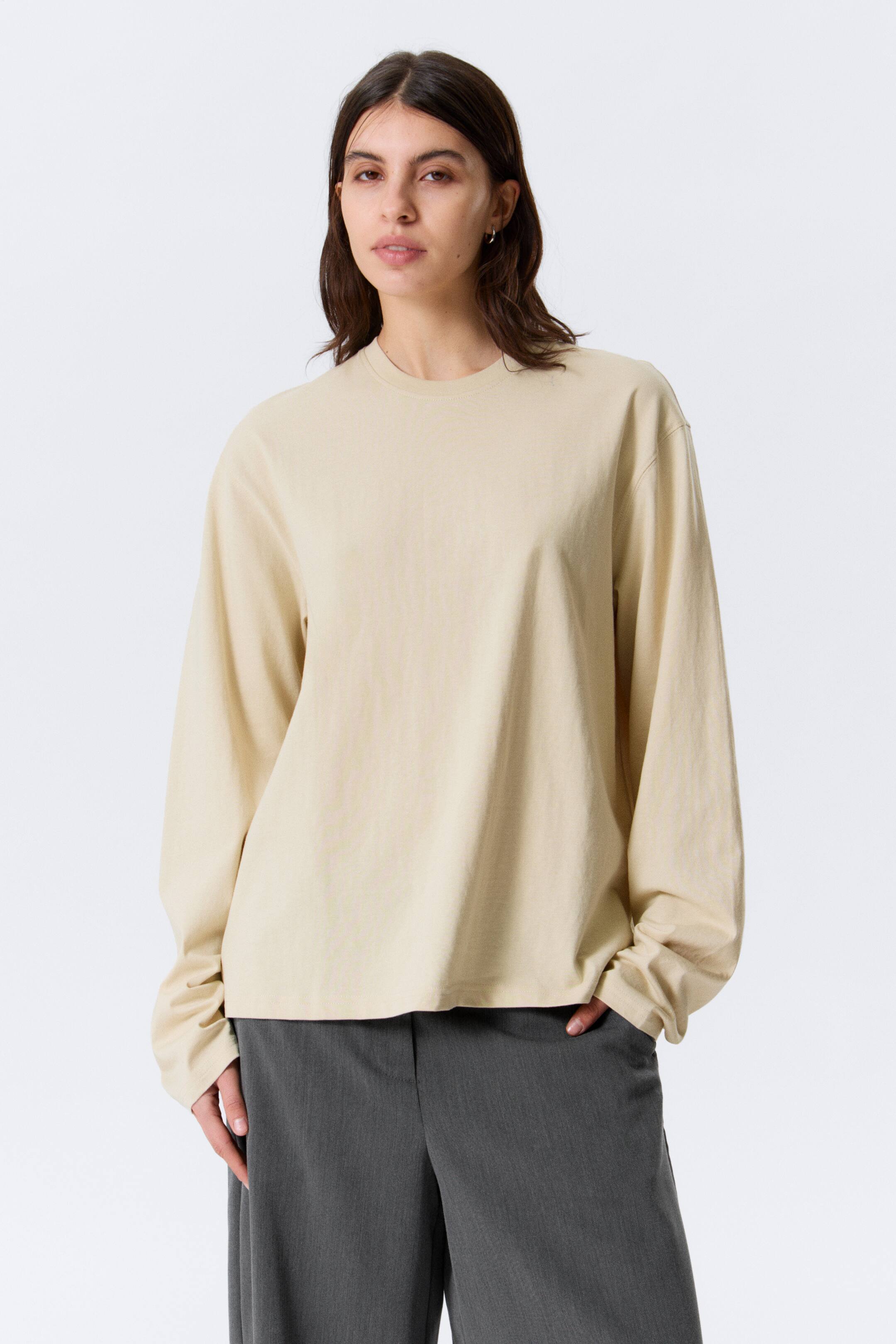Visa större bild: En beige långärmad topp med rund hals, avslappnad passform, långa lösa ärmar och rak fåll.