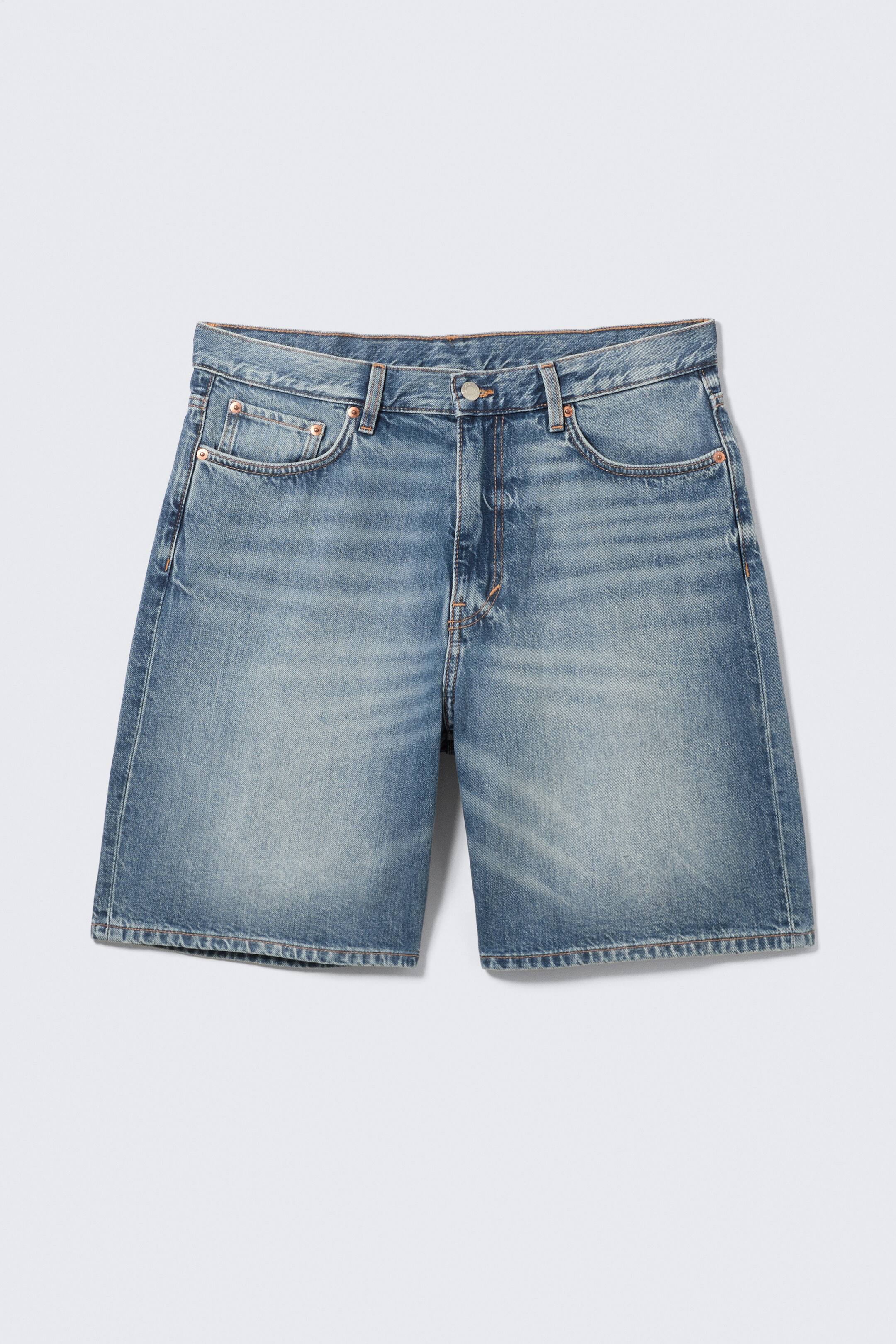 Agrandir l'image: Un short en denim rigide bleu clair est présenté de face, avec une coupe ample et décontractée. Le short est conçu dans un style classique à cinq poches, comprenant des poches avant incurvées et une poche à monnaie, ainsi qu'une fermeture à boutons.
