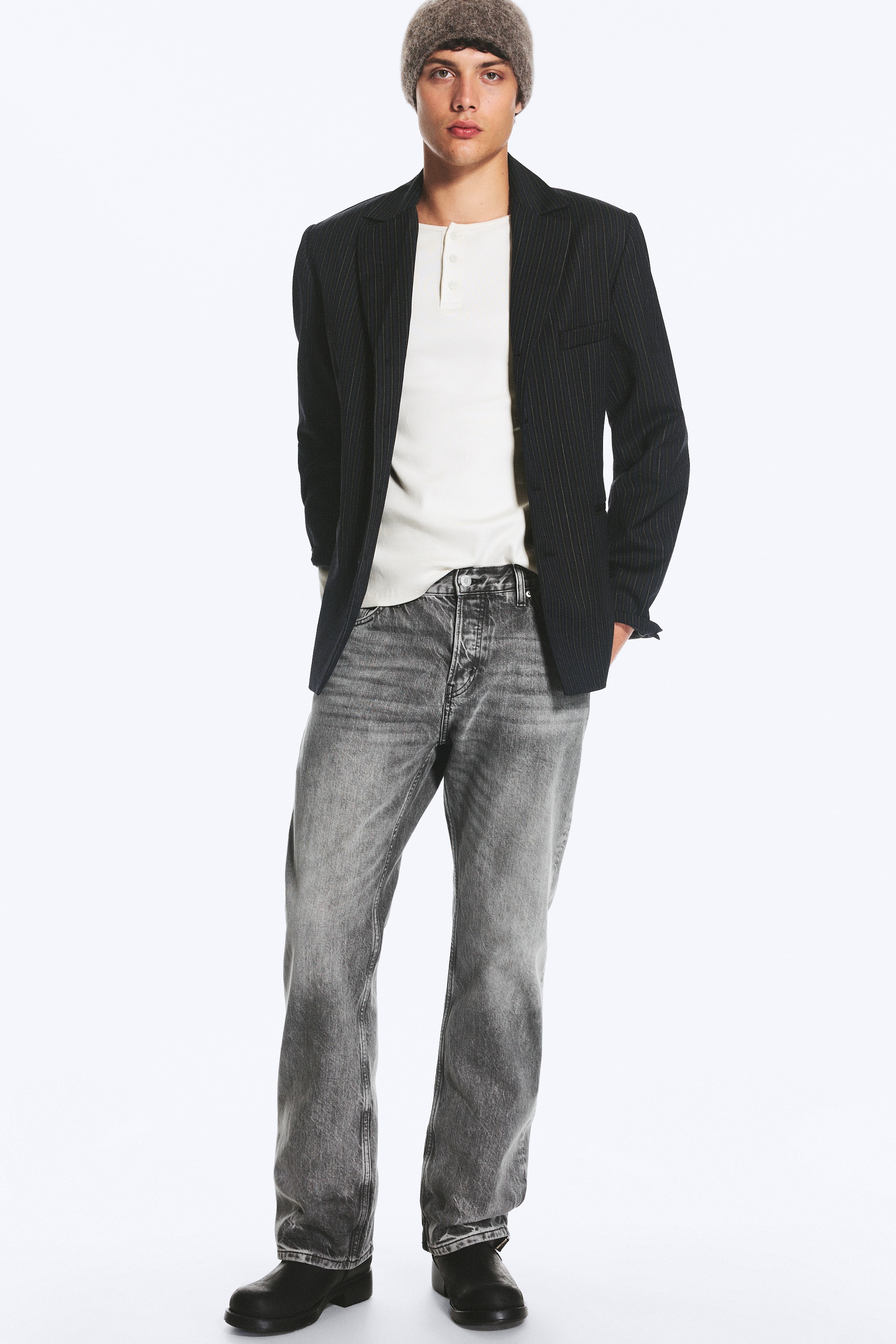 Eine graue Jeans mit mittlerer BundhÃ¶he ist von vorn zu sehen und zeigt eine lockere Passform sowie eine gerade Beinsilhouette. Die Jeans verfÃ¼gt Ã¼ber eine ausgewaschene Optik an Oberschenkeln und HÃ¼ften, ein klassisches Five-Pocket-Design und einen Knopfverschluss am Bund.