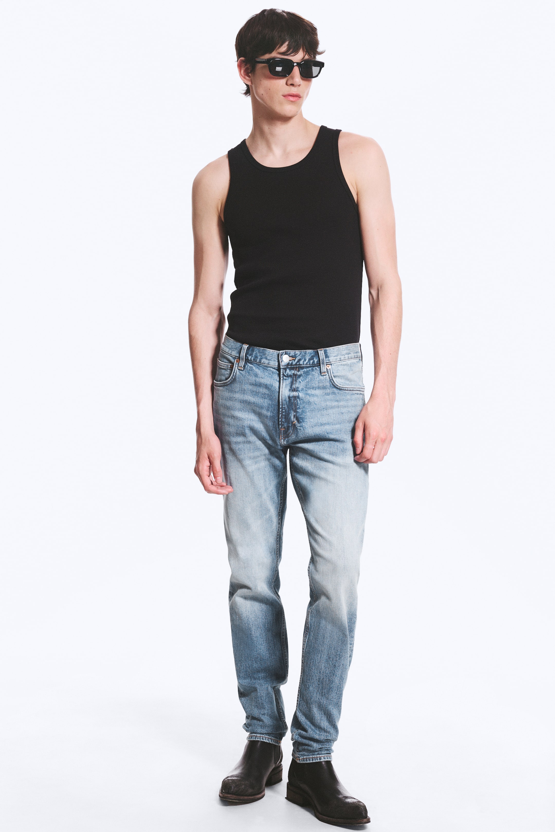 Grotere afbeelding bekijken: Lichtgewassen denim jeans tonen een vervaagde lichtblauwe kleur met een versleten uitstraling en donkerdere vervaging naar de onderkant toe. Ze hebben een rechte pasvorm, een zichtbare knoopsluiting en voorzakken, allemaal naar voren gericht.