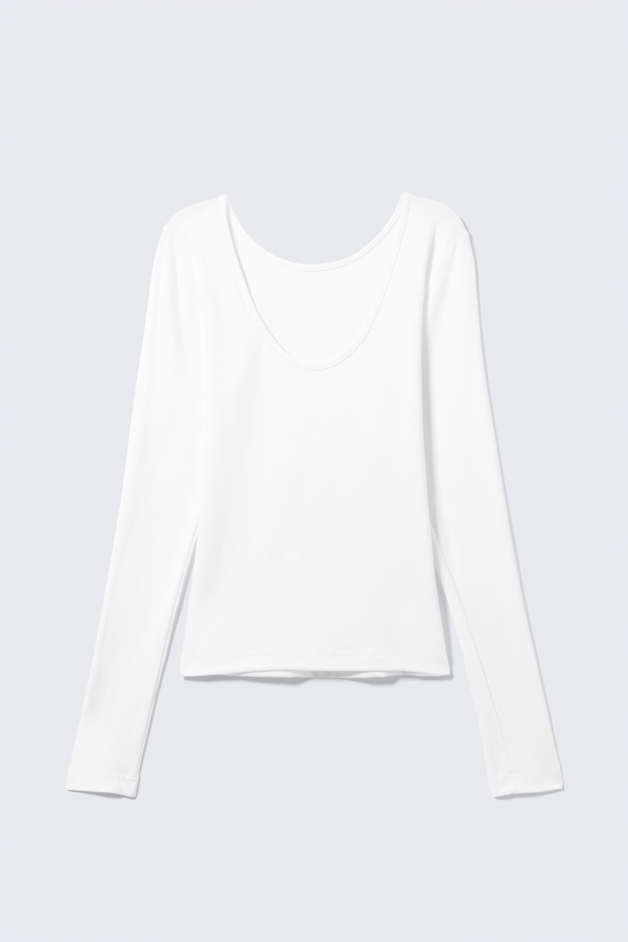 Grösseres Bild ansehen: Ein weisses Langarmshirt wird von vorne präsentiert und zeichnet sich durch einen weit geschnittenen Rundhalsausschnitt aus. Es zeigt eine schlanke Passform und sauber verarbeitete Säume.