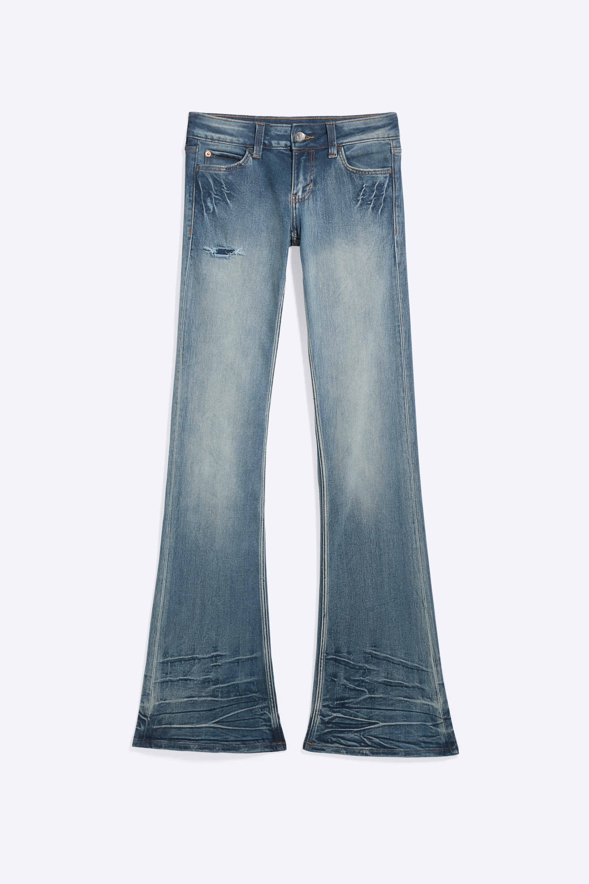 NÃ¤mÃ¤ matalavyÃ¶tÃ¤rÃ¶iset bootcut-farkut haalistuneessa sinisessÃ¤ pesussa on kuvattu edestÃ¤. NiissÃ¤ on vartalonmyÃ¶tÃ¤inen istuvuus reidestÃ¤ ja hillitty levennys lahkeensuussa. Farkuissa on viiksitystÃ¤ lantiolla ja kevyitÃ¤ kulutettuja yksityiskohtia, ja ne on stailattu cropatun hupparin kanssa korostamaan matalaa vyÃ¶tÃ¤rÃ¶ratkaisua.