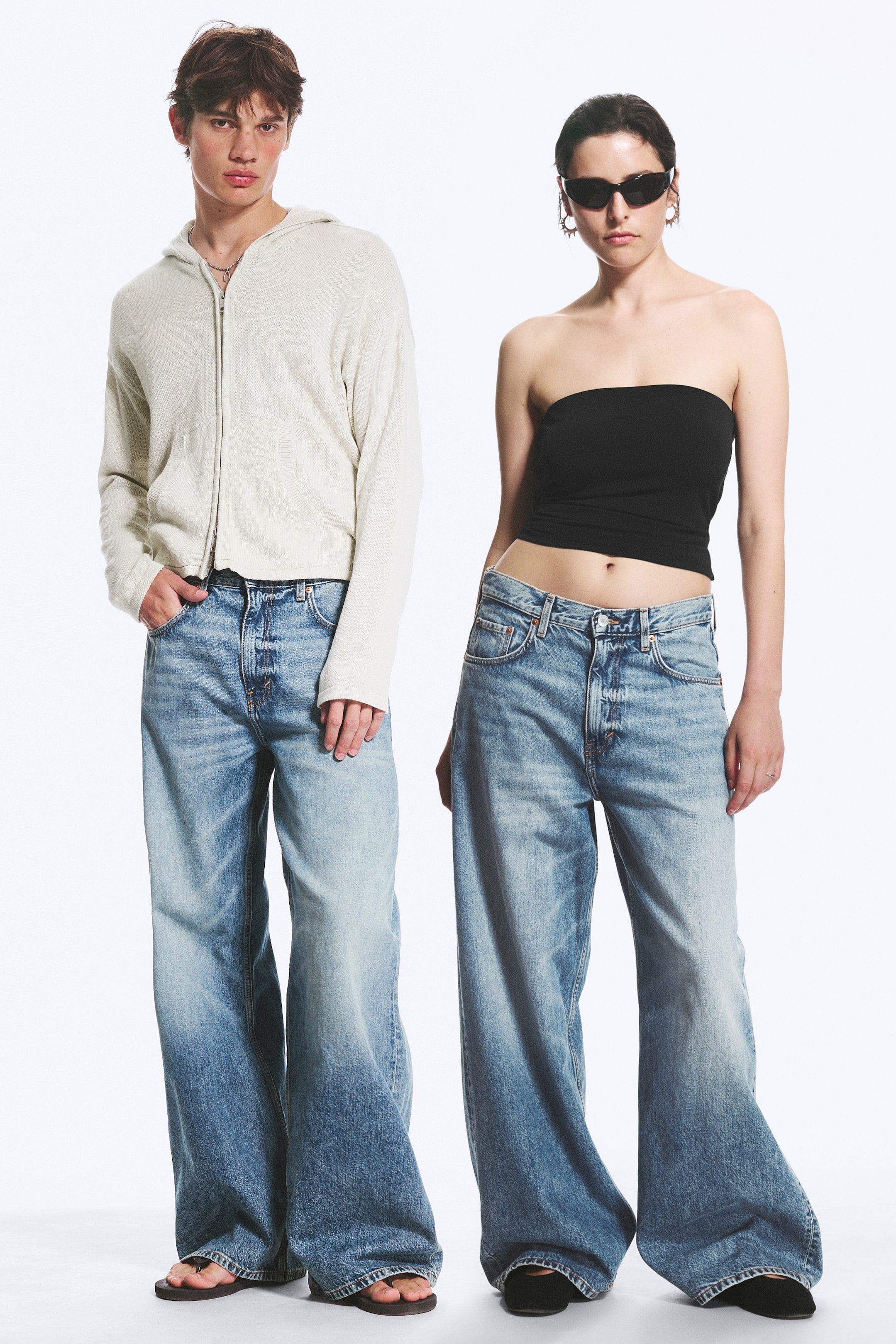 Se større billede: De lyse, vaskede wide-leg jeans har en falmet blå denim med en gradient effekt, der går fra lysere blå ved lårene til en mørkere blå ved sømmen. De er designet med en afslappet, wide-leg silhuet og en synlig knaplukning, der fremhæver en løs pasform.