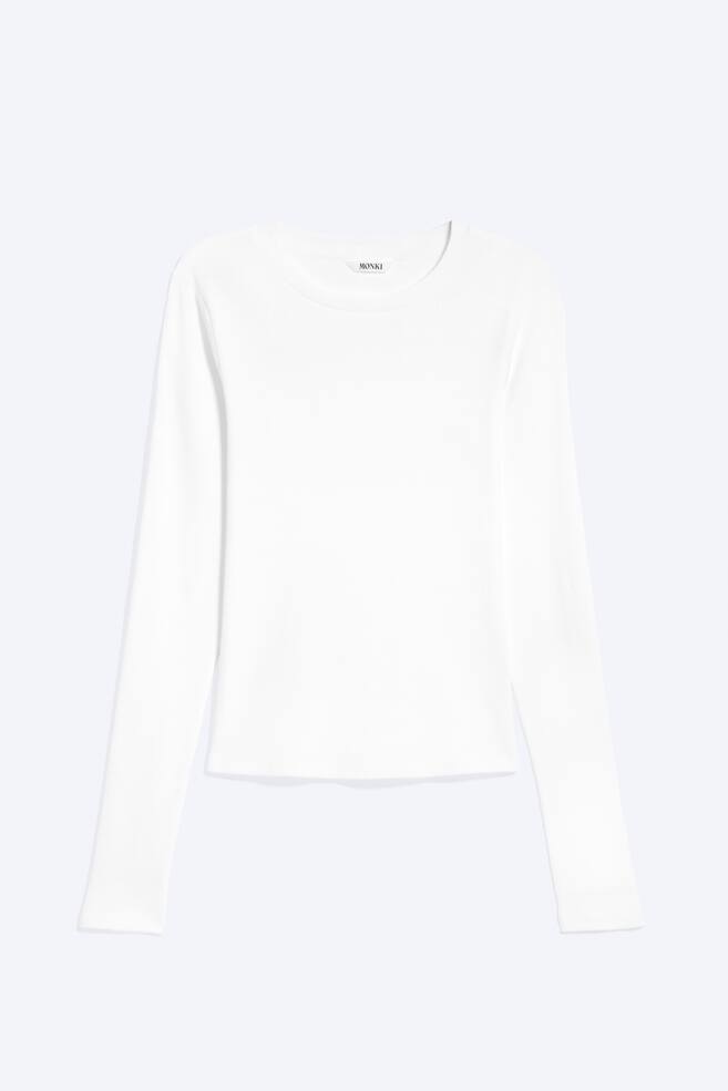 Een witte geribbelde top met lange mouwen wordt van voren weergegeven, met een ronde hals en een zichtbaar 'MONKI' merketiket. - 1