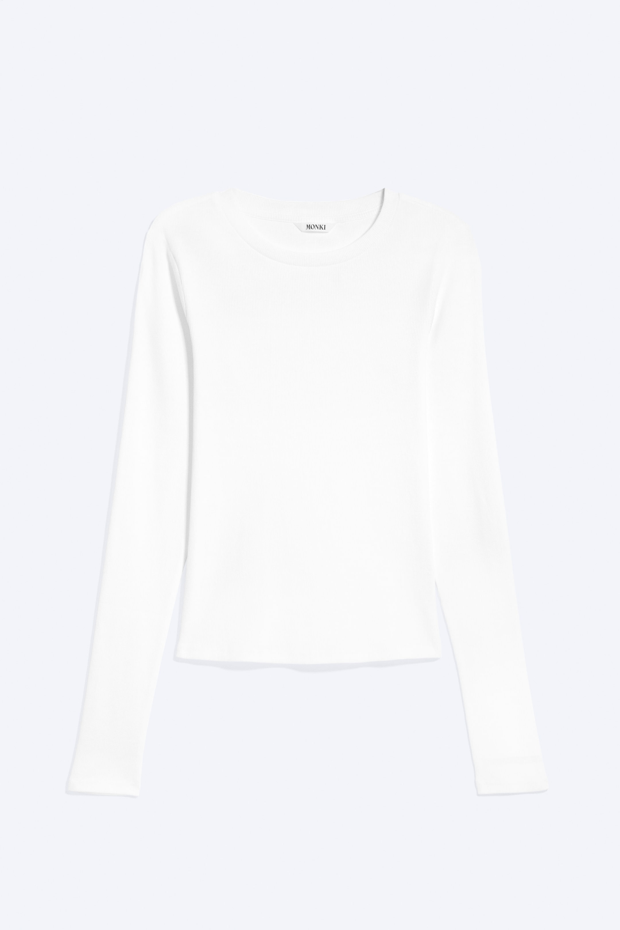 Agrandir l'image: Un haut blanc à manches longues côtelé est présenté de face, avec un col rond et une étiquette de marque visible "MONKI".