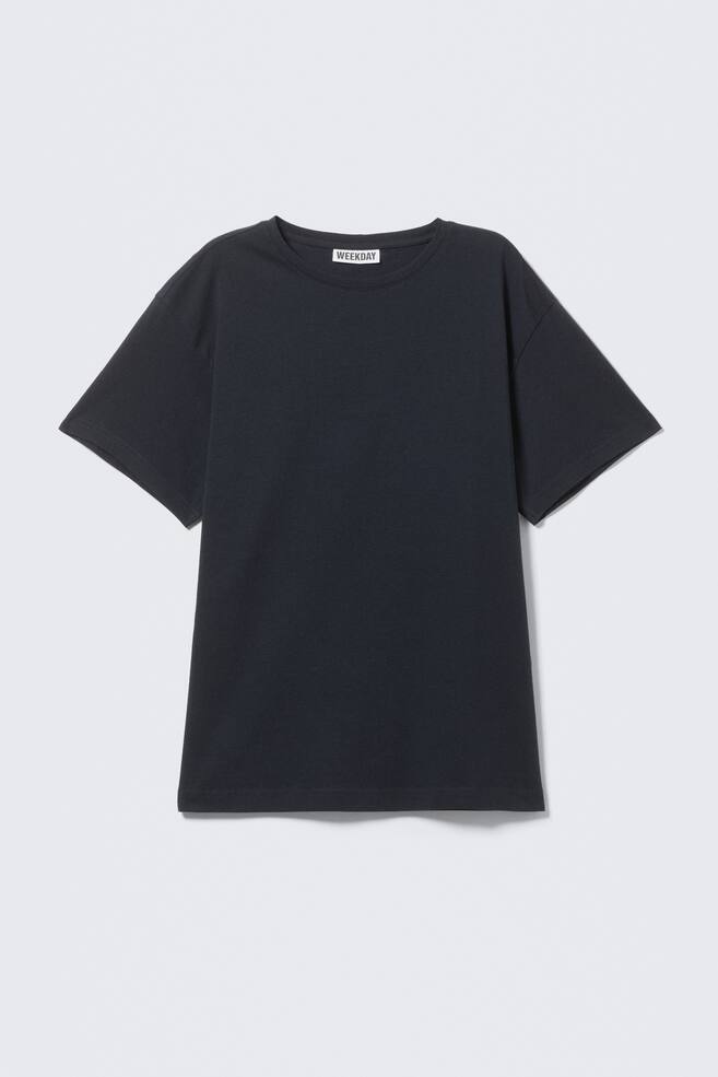 A black short-sleeved T-shirt is showcasing its front, featuring a classic crew neckline and a straight hem. A white "WEEKDAY" label is visible at the back of the collar, and the shirt is offering a regular fit. - 1