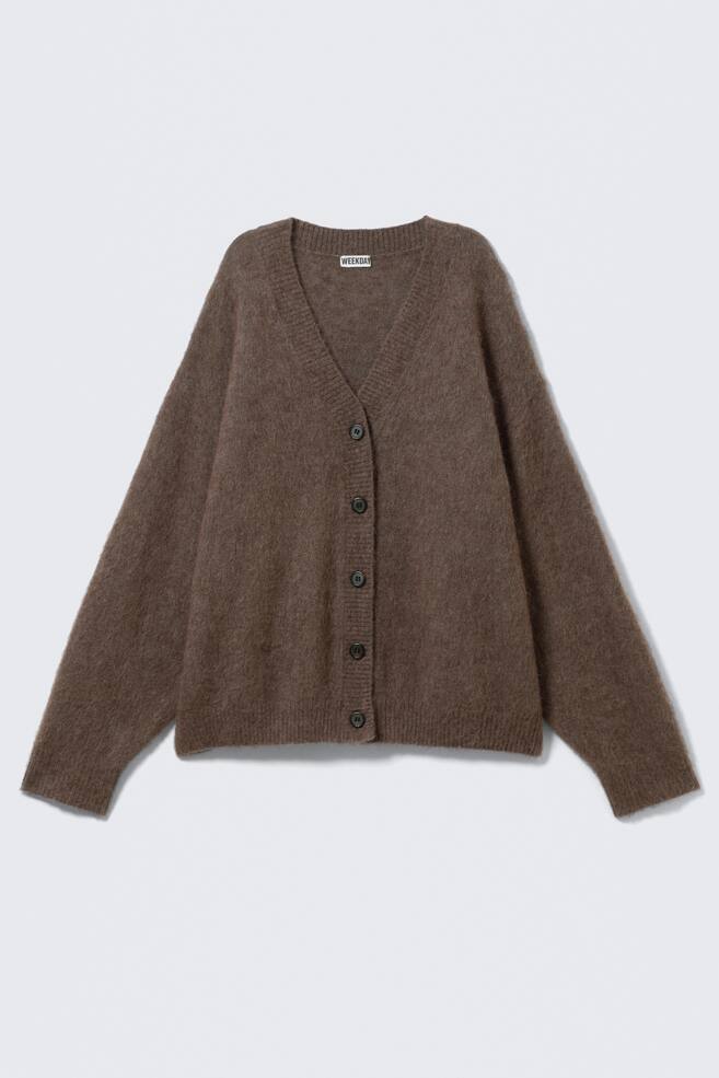 A brown V-neck cardigan is showcasing its FRONT, displaying a loose, relaxed silhouette and a soft, fuzzy knit texture. It features dropped shoulders, a full button front with six dark buttons, and ribbed cuffs and hem. - 1